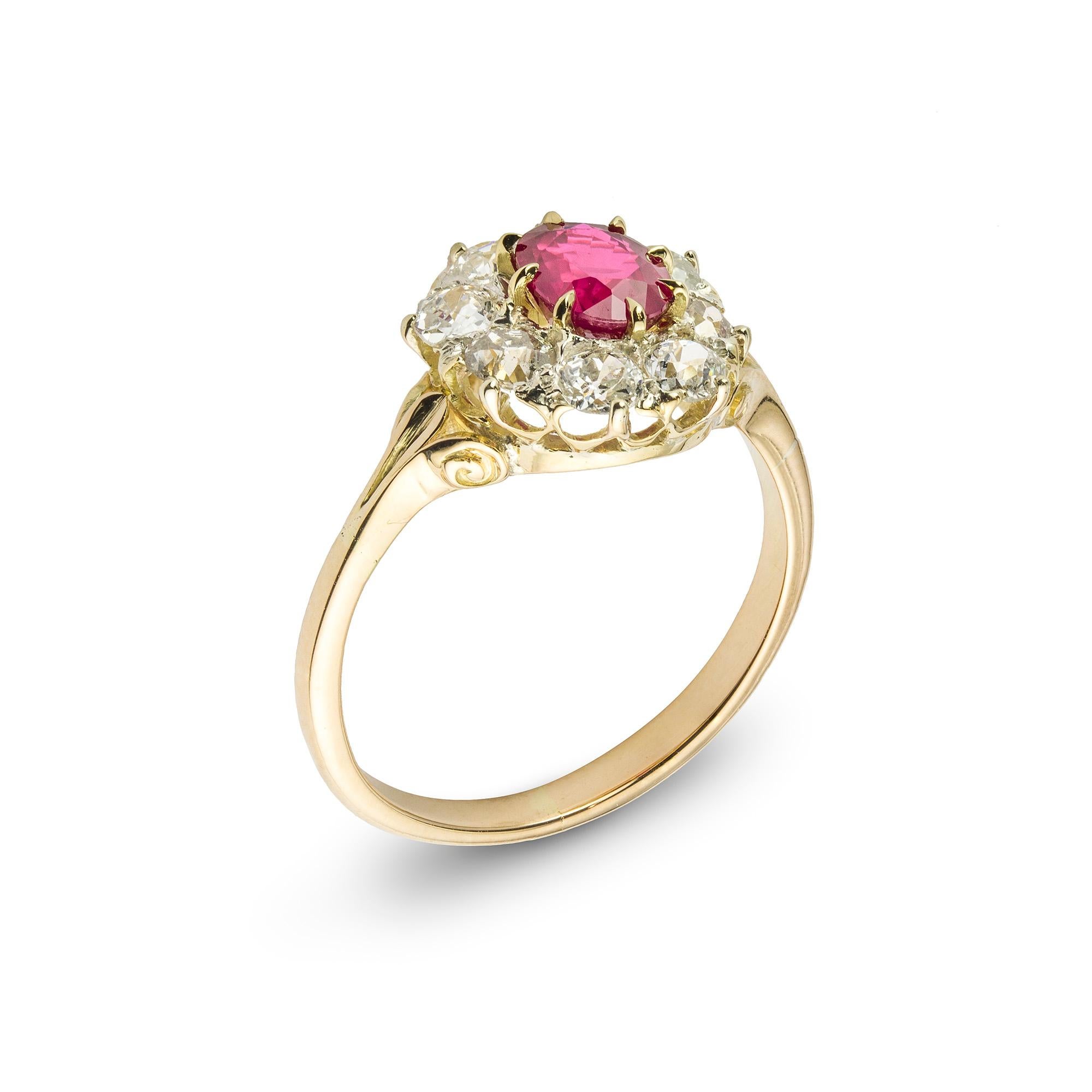 A late Victorian ruby and diamond cluster ring, the oval-cut ruby weighing 1.09 carats of Burmese origin, surrounded by eight old European-cut diamonds estimated to weigh 1 carat in total, all claw-set to a scrolled mount with split shoulders,