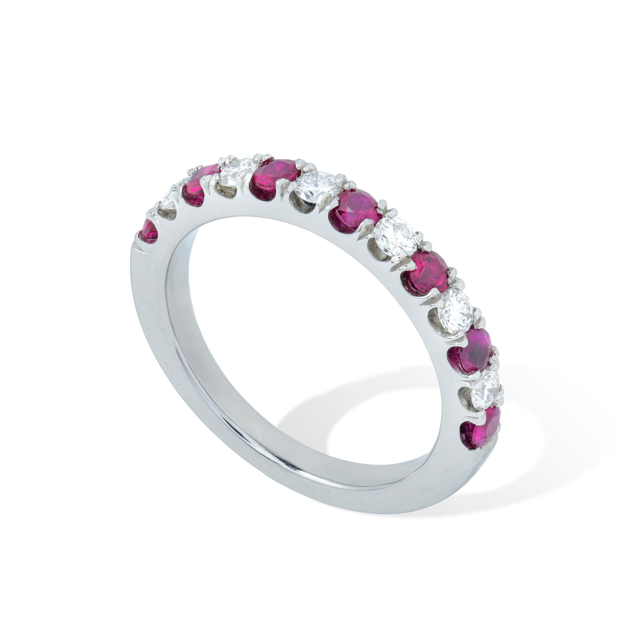 A ruby and diamond half eternity ring, the seven round-cut faceted rubies, weighing a total of 0.52 carats, alternately set between six diamonds weighing a total of 0.31 carats, all claw-set to a platinum mount, finger size M, gross weight 5.78