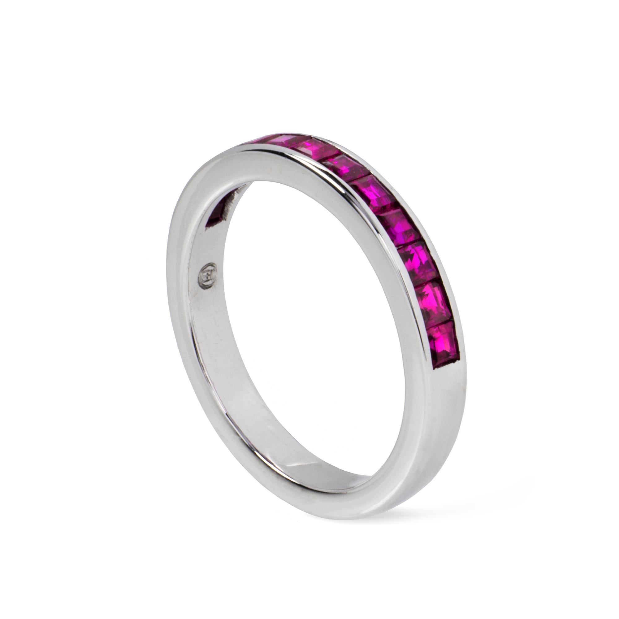 A ruby half eternity ring, set with 12 square cut rubies estimate to weigh a total of 0.75 carats all channel set in white gold, hallmarked 18ct gold, London 2018, bearing the Bentley and Skinner sponsor mark, the head measuring approximately 20 x