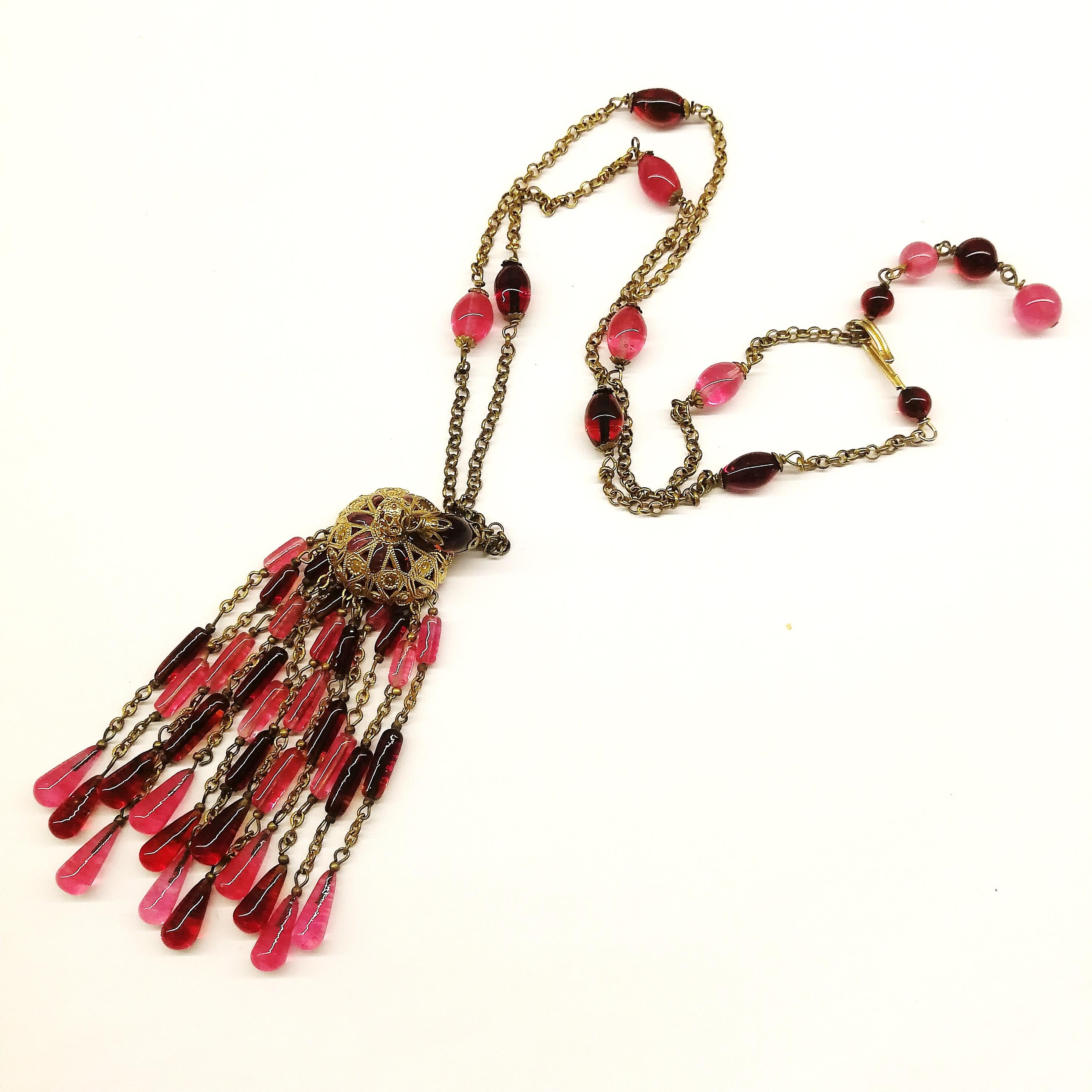 A beautiful, elegant ruby/cranberry poured glass necklace, a sautoir with a rich tassel pendant, crowned with a gilt filigree and poured glass cap, it is made by haute couture artisans, Maison Gripoix, in the 1960s, with fine, delicate workmanship