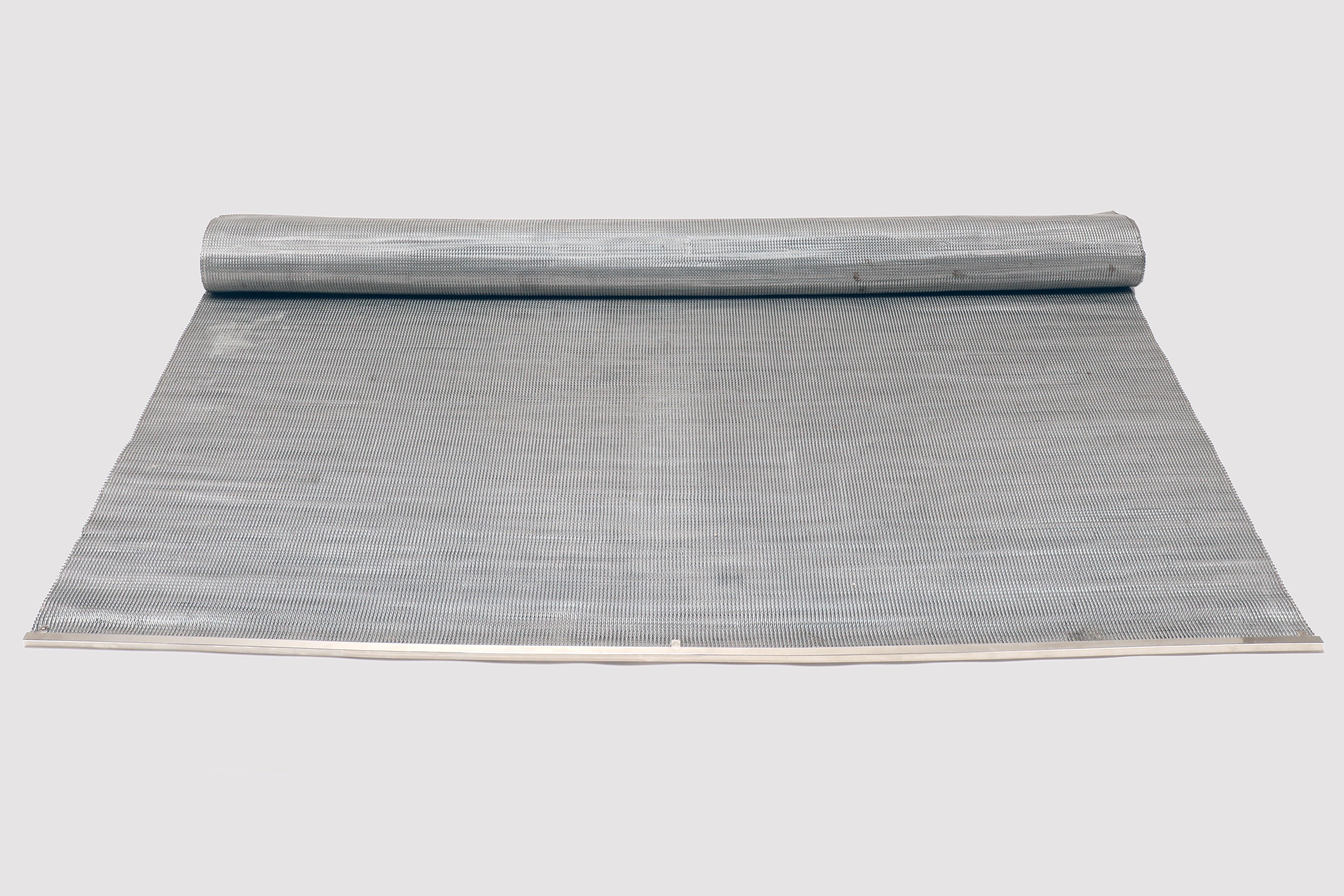 Un esempio di reinterpretazione e reimmaginazione di un vecchio elemento. Un pezzo di nastro trasportatore in filo d'acciaio lavorato a maglia e articolato, utilizzato per scopi industriali, ora utilizzato come tappeto. Stati Uniti, inizio del XX