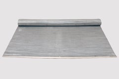 A rug made of woven steel wire, from a conveyor belt, USA early 20th century.