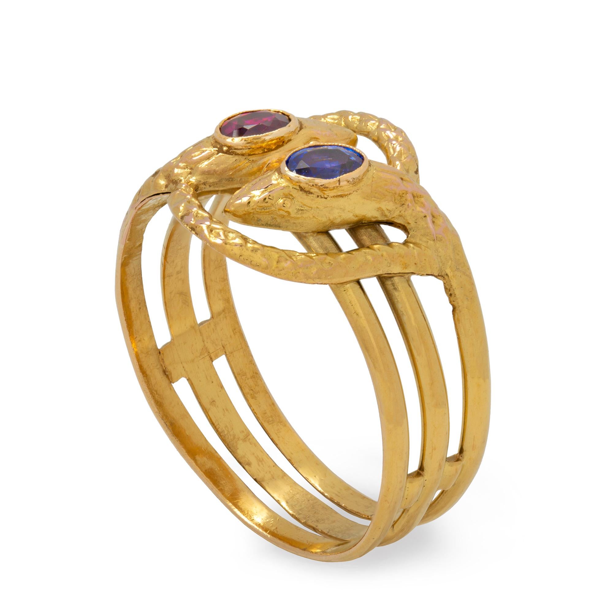 A Russian gold and gemset twin serpent ring, the two serpents entwined the head of one set with an oval-shaped sapphire, the other with an oval-shaped ruby, all set in gold, marked 56 zolotnik,  circa 1910, measuring approximately 0.7 to 1.5cm in