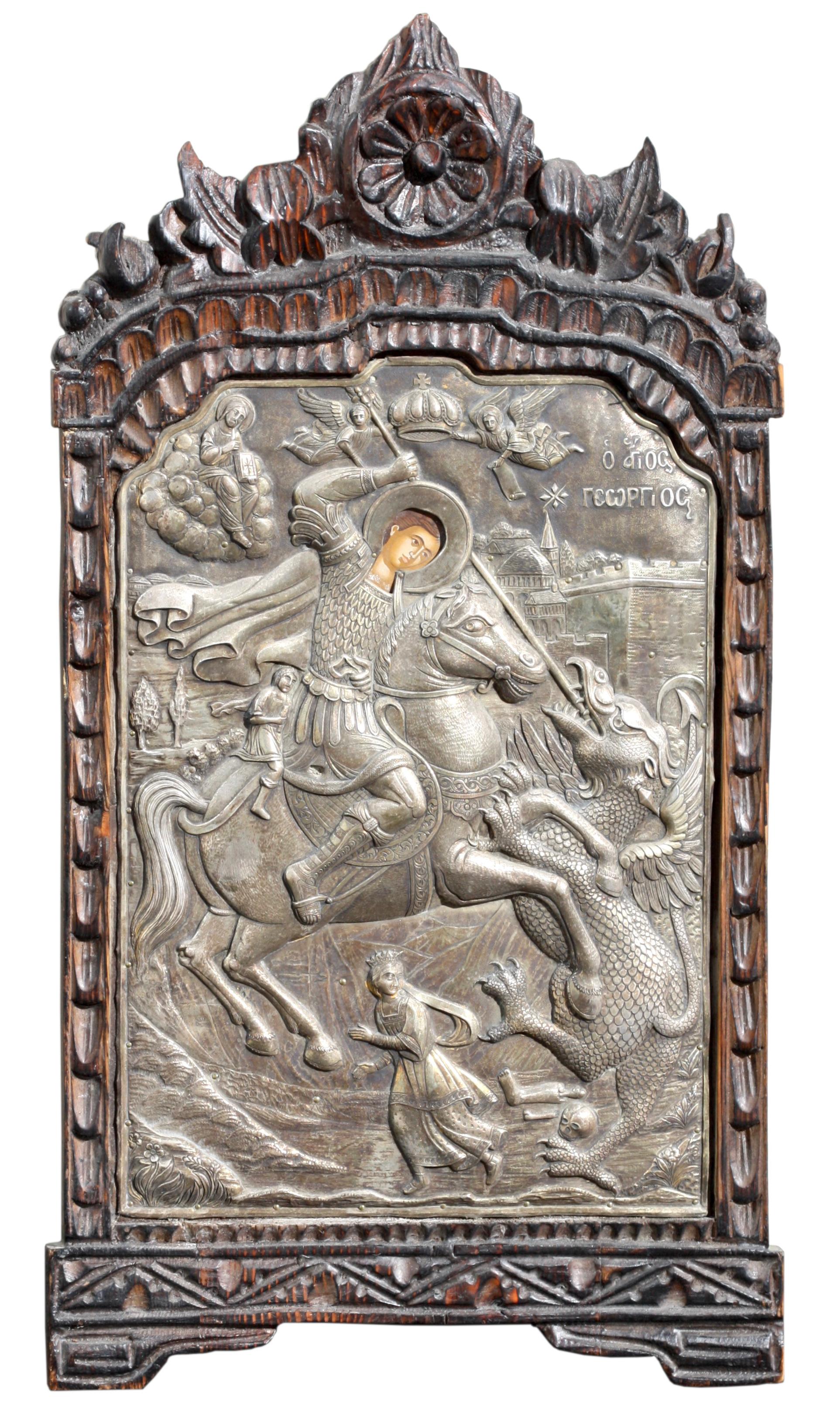 A Russian Silver Icon of St George, depicting the saint slaying the dragon, struck to the lower edge with maker's mark, 950 standard, within an elaborately carved frame.
Measuring 24.5 by 13 inches (62.23 x 33.02 cm.)