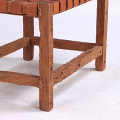 A rustic French wood bench with woven leather seat, C. 1930.