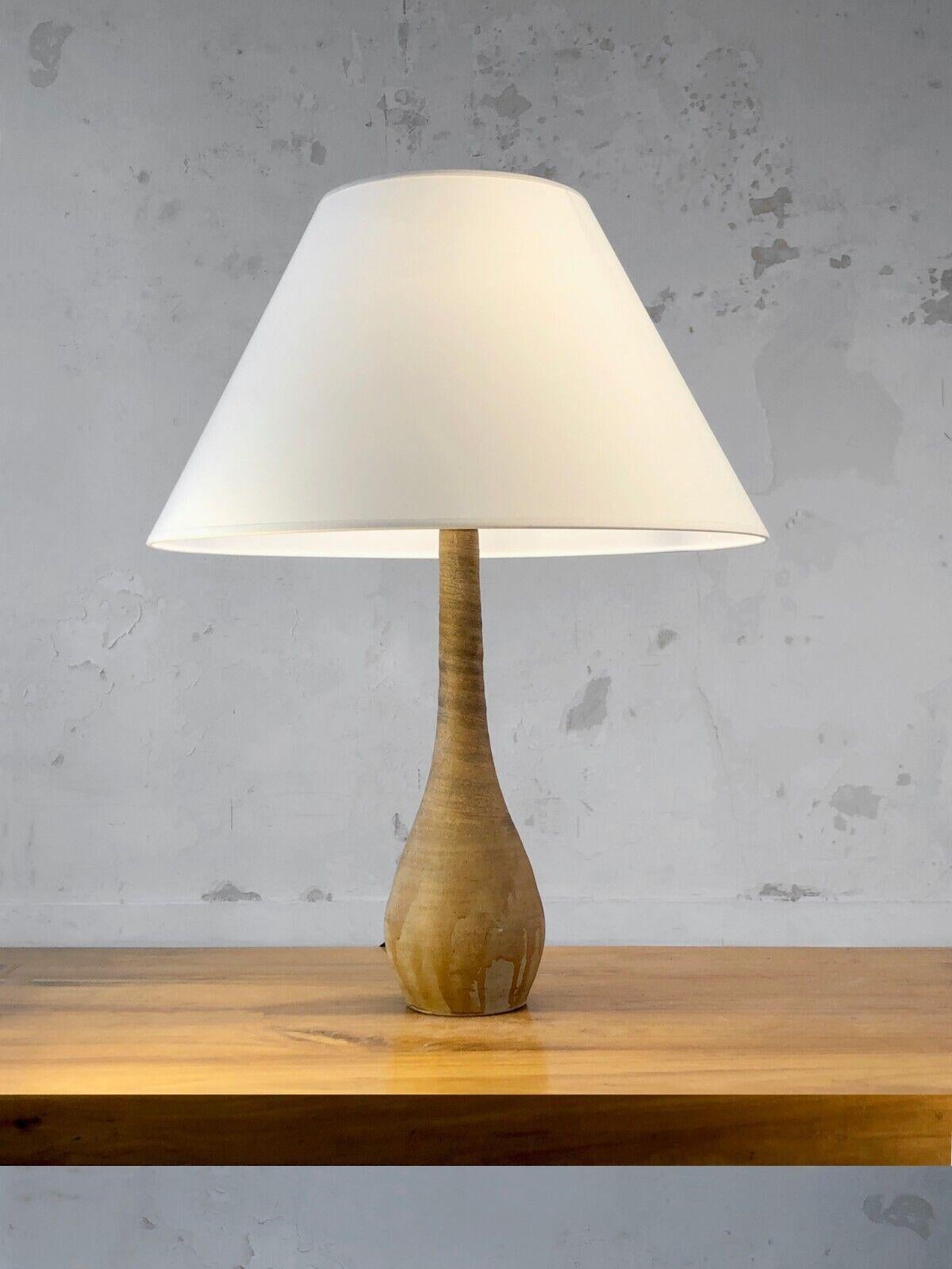 An elegant table lamp, Post-Modernist, Brutalist, Popular Art, Shabby-Chic, Rustic Modern, with a curved Forme-Libre body in very raw earthy sandstone with a twisted movement irregularly enameled with a few drips, to be attributed, La Borne, France