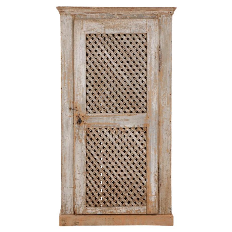 A rustic painted pine one-door cabinet, early 19th C.