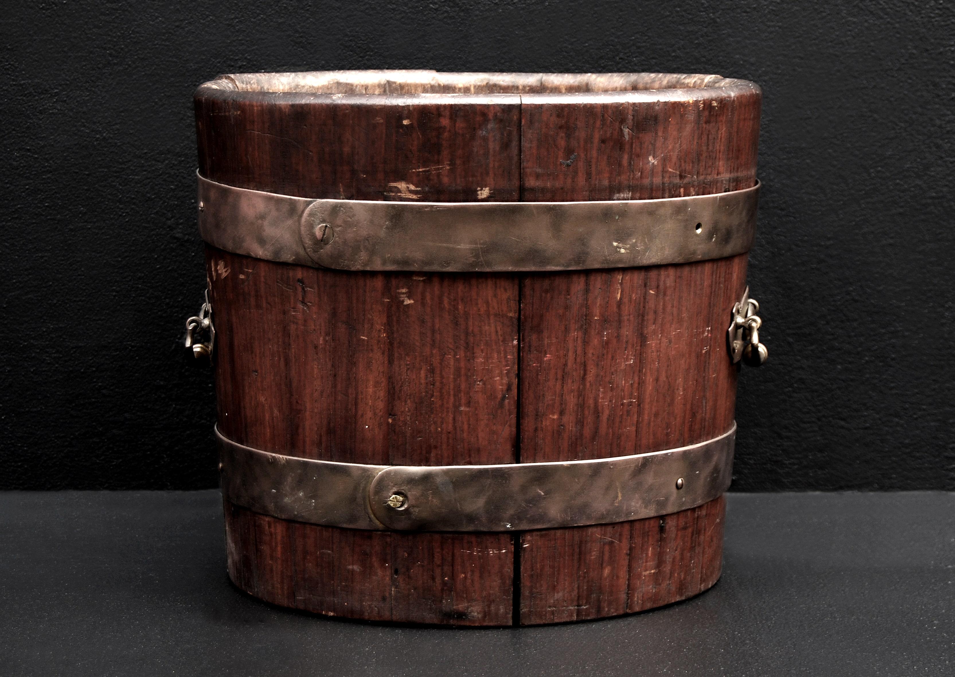 Late 19th century English mahogany coal bucket with brass banding and brass handles.(Handles possibly added later.) Original removable metal lining. 

Height:	310 mm      	12 ¼