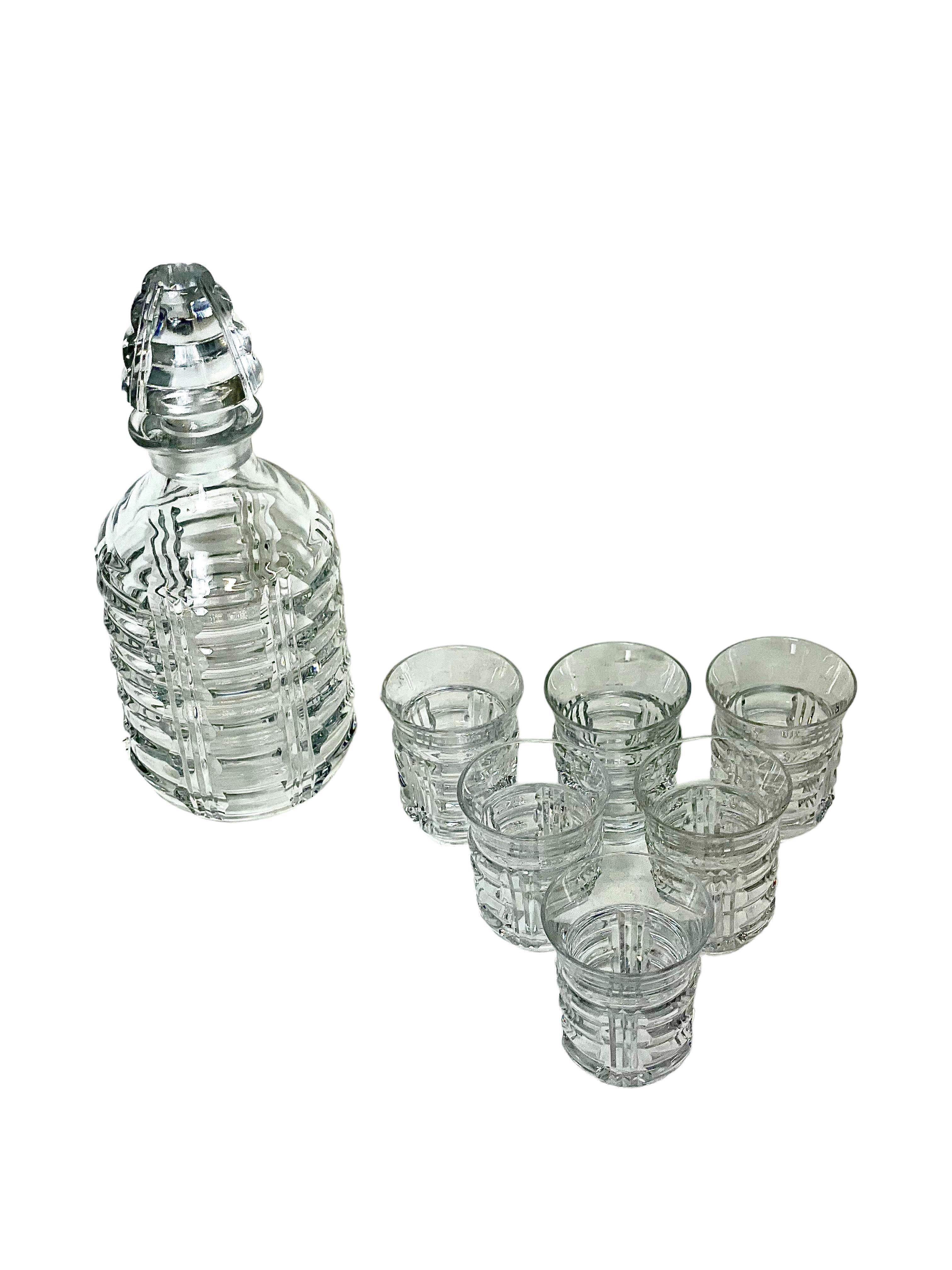 A Saint Louis crystal port decanter and six tumbler glasses, delightfully embellished with a tactile and geometric design of gently undulating waves. The bottle-shaped decanter has its original, tightly-fitting and multi-faceted ball stopper, and is