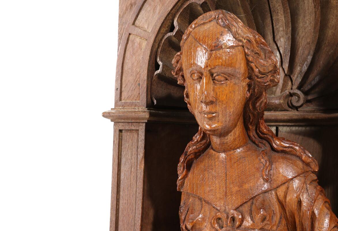 A sainte with shield. A Renaissance carved oak figure, standing in a later oak niche, 18th-19th century.