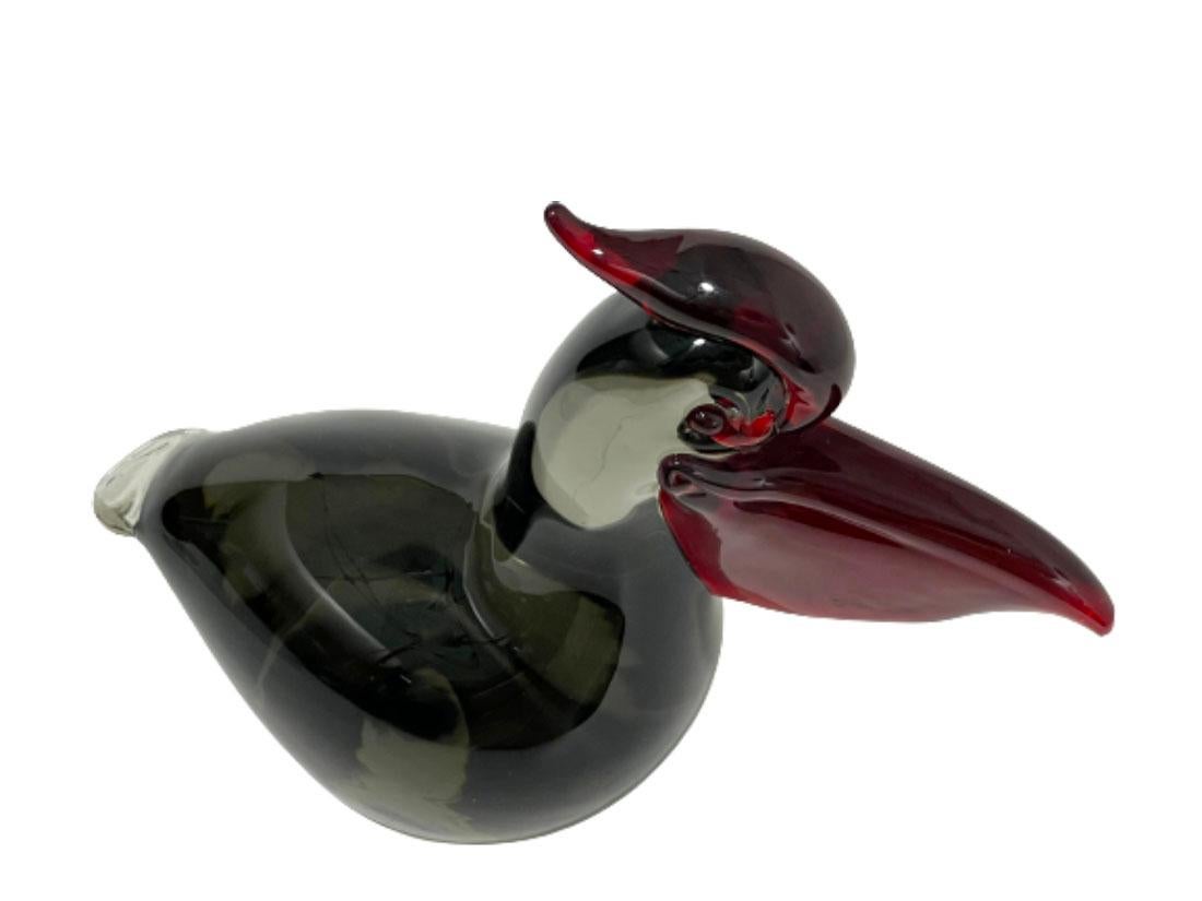 A Salviati & Company Murano glass bird figure, 1960s. 

An Italian hand-blown glass sculpture in the shape of a pelican, made by Salviati & Company in Venice. A brown, gray colored transparent glass with a red comb, eyes and beak in transparent