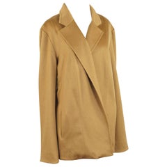 Una giacca in cashmere Sam Kori George, in cashmere color cammello con fodera in seta.