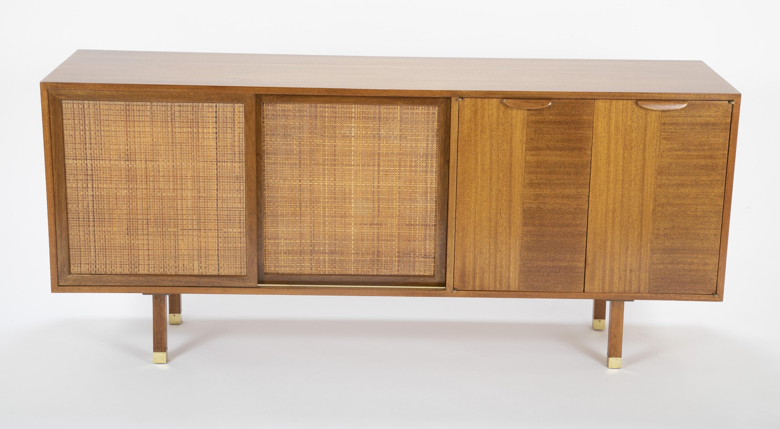 A Harvey Prober credenza formerly a record / stereo cabinet. Produced by Prober Inc. Sapele mahogany case with cane doors and brass caped feet.
