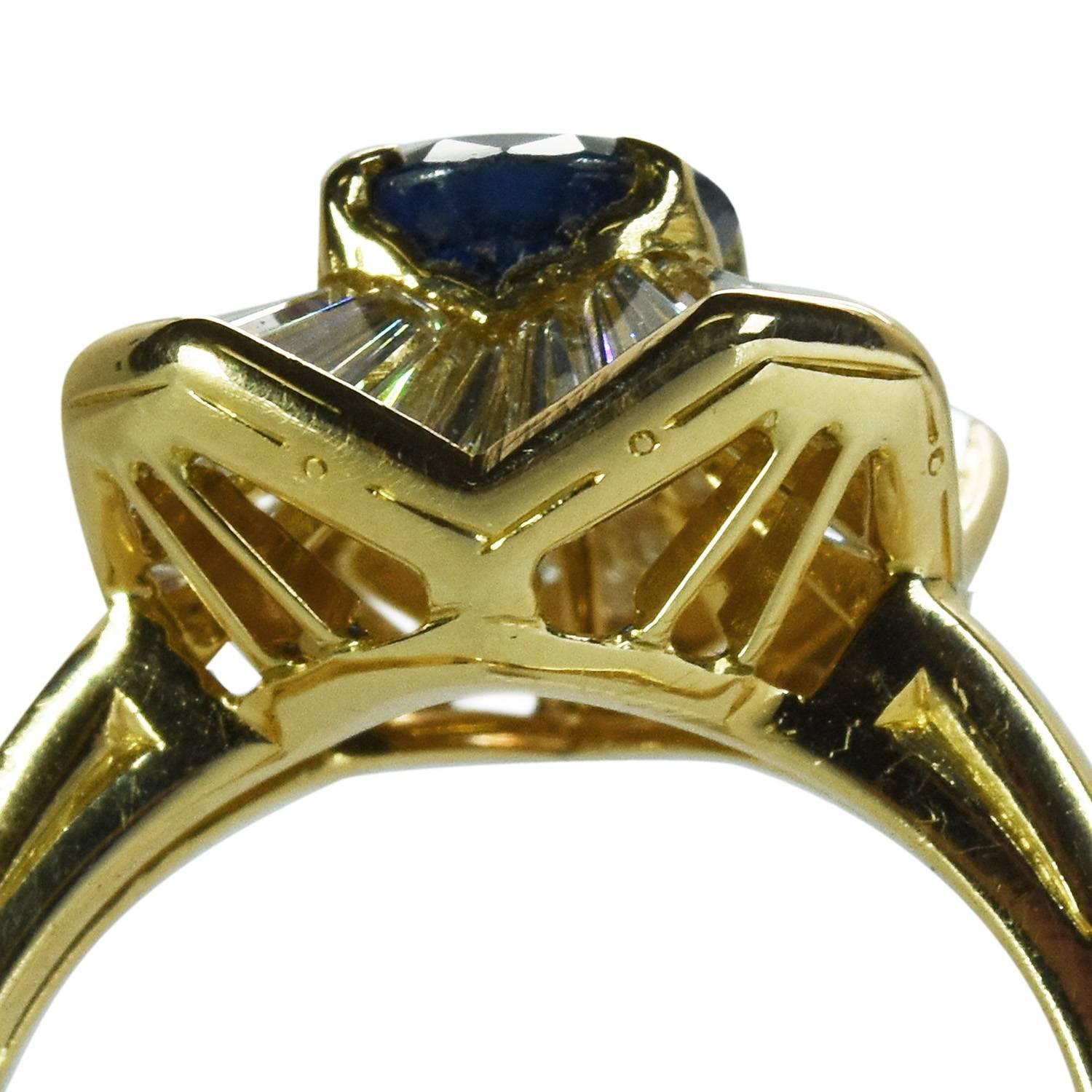 A Sapphire and Diamond Ring by iconic design house Oscar Heyman & Brothers. The ring features an oval sapphire weighing approximately 1.13 carats surrounded by tapered baguette diamonds totaling approximately 1.85 carats. The ring stamped 18k and