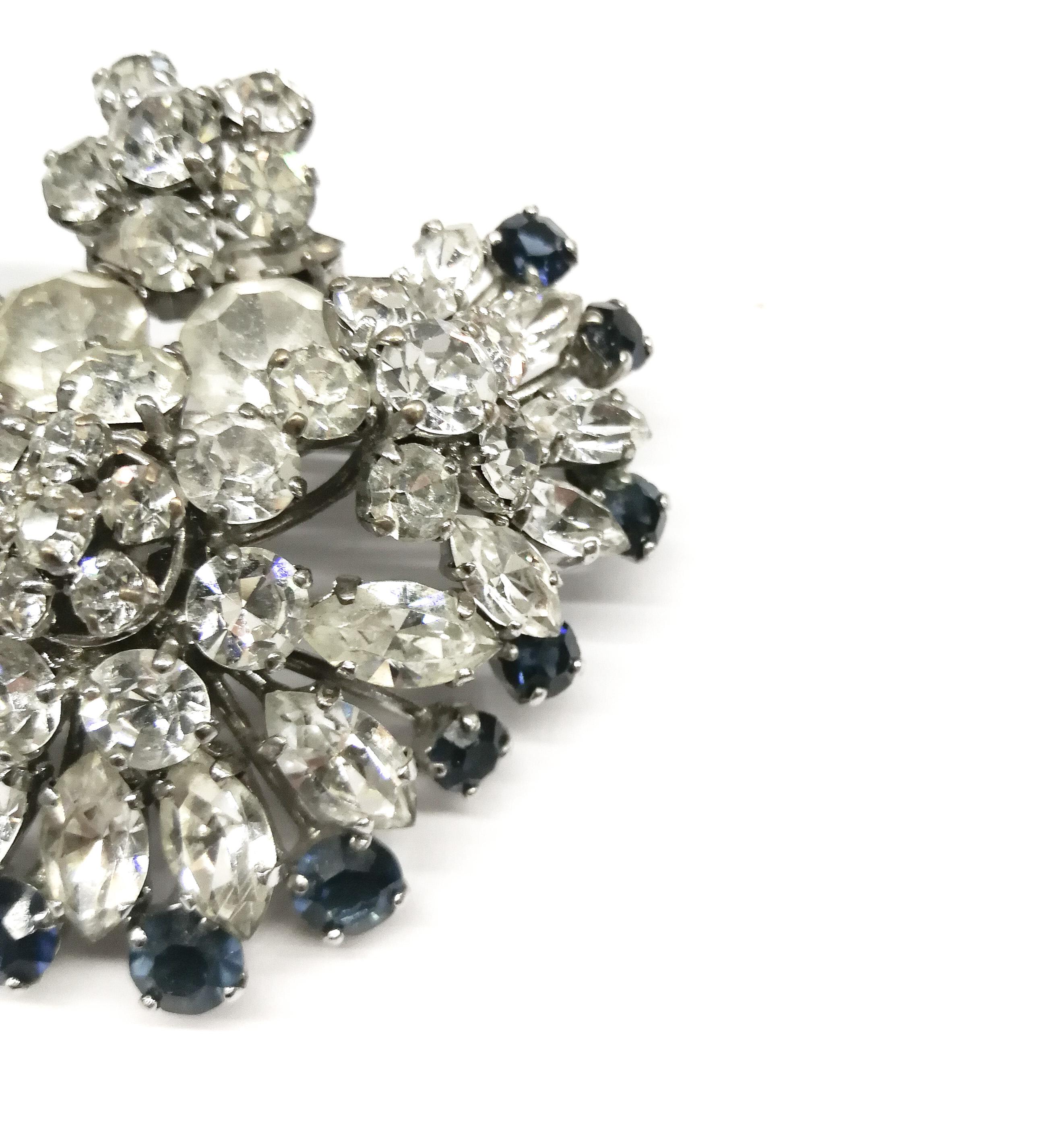 A striking brooch, made by Henkel and Grosse for Christian Dior in 1959 (the brooch is marked and dated). Charming and glamorous, it is very three dimensional, consisting of mainly clear pastes with sapphire pastes around the edge of the brooch. It