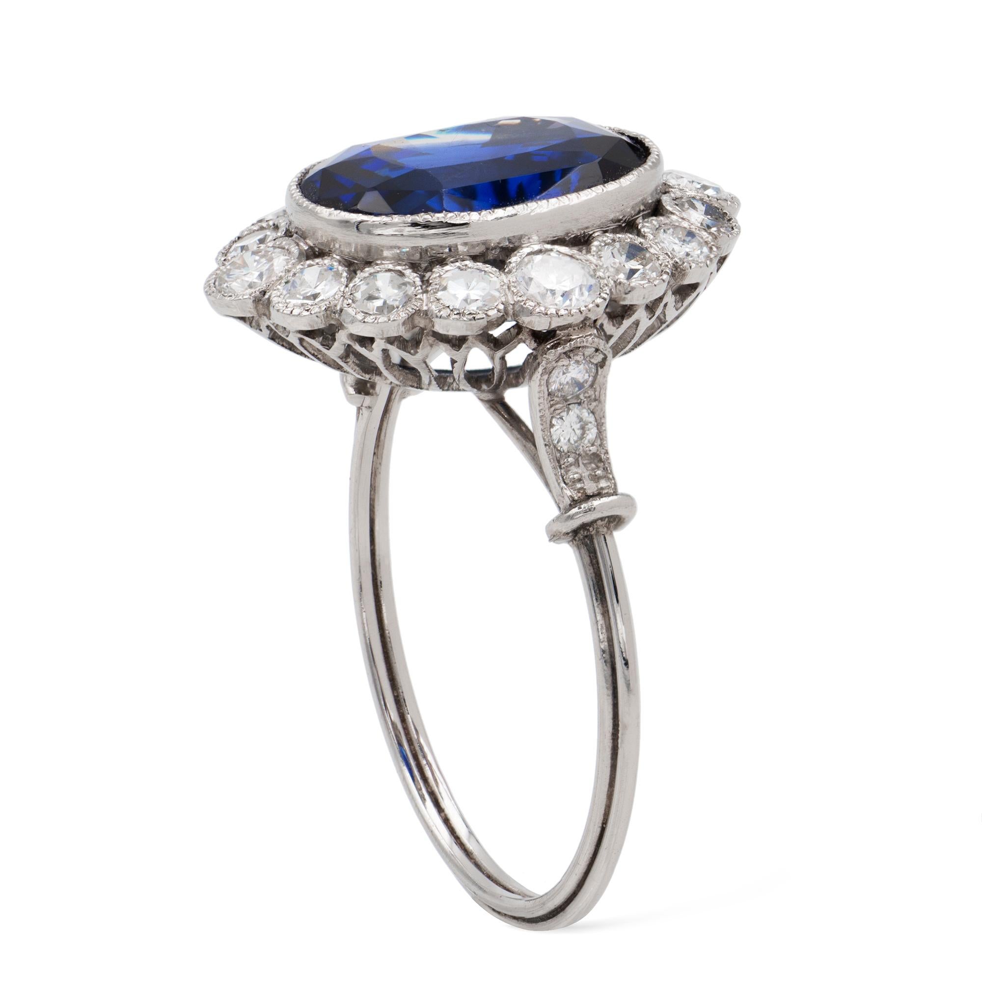 A sapphire and diamond cluster ring, the oval faceted sapphire estimated to weigh 4.4 carats, accompanied by GCS Report  stating to be of Sri Lankan origin with no indication of heating, surrounded by sixteen brilliant and swiss-cut diamonds