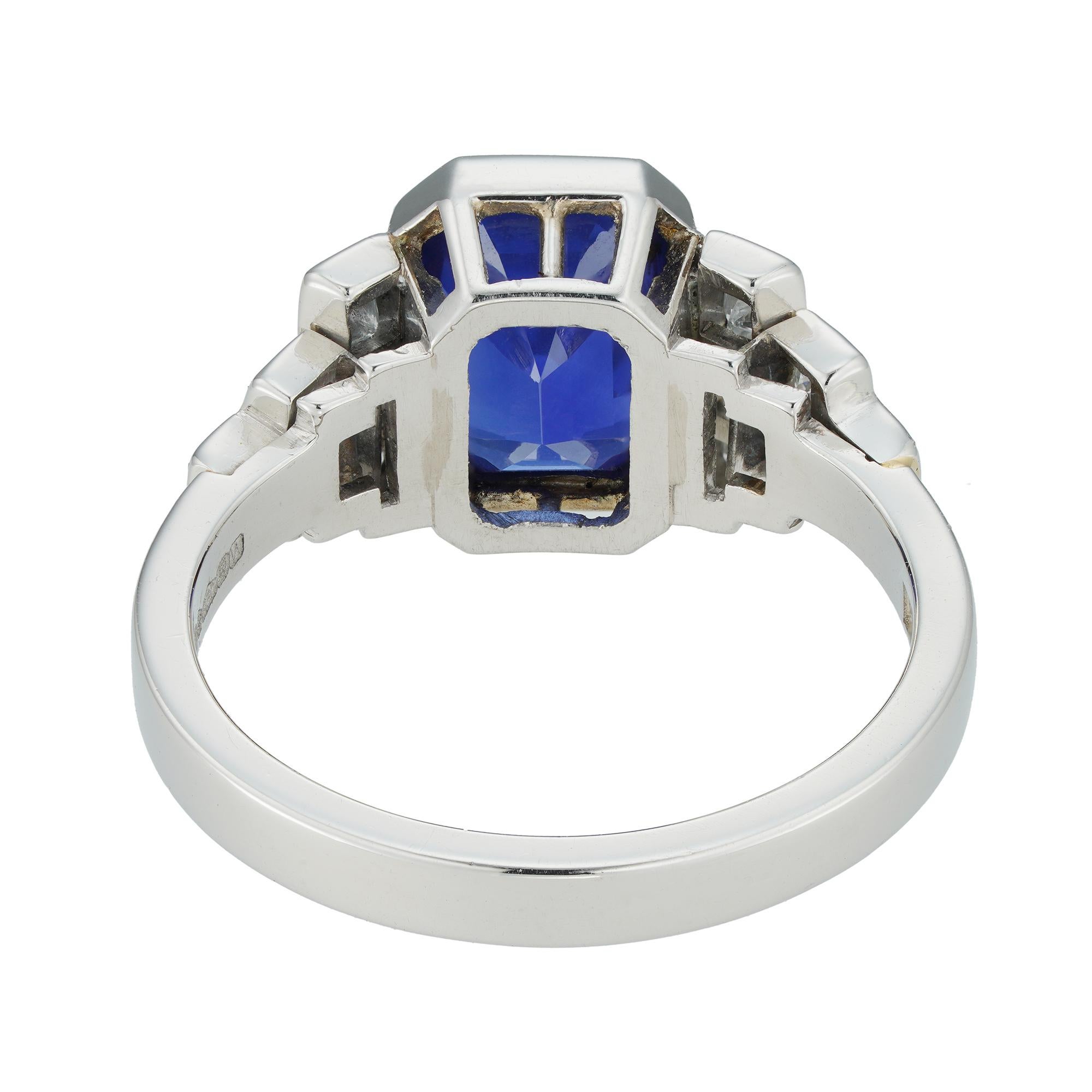 A sapphire and diamond ring, the octagonal-cut sapphire weighing 3.03 carats, rub-over set between three graduated stepped shoulders on each side, set with twelve princess-cut diamonds estimated to weigh 0.4 carats in total, all mounted in platinum,