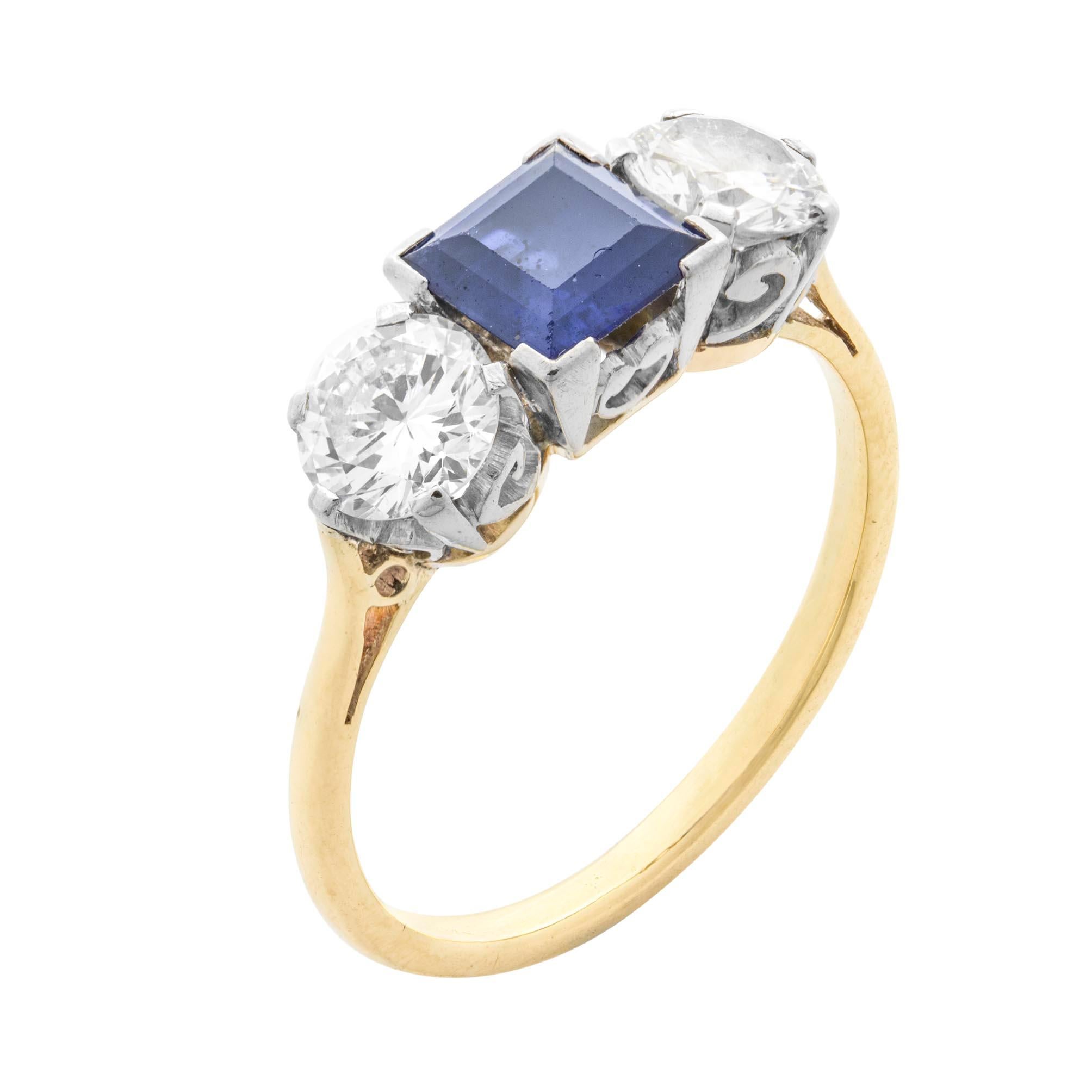 A sapphire and diamond three stone ring, the square-cut sapphire weighing 0.98 carats, set between two round brilliant-cut diamonds, the one weighing 0.49 carats of F colour and SI2 clarity, the other weighing 0.46 carats of F colour and SI1