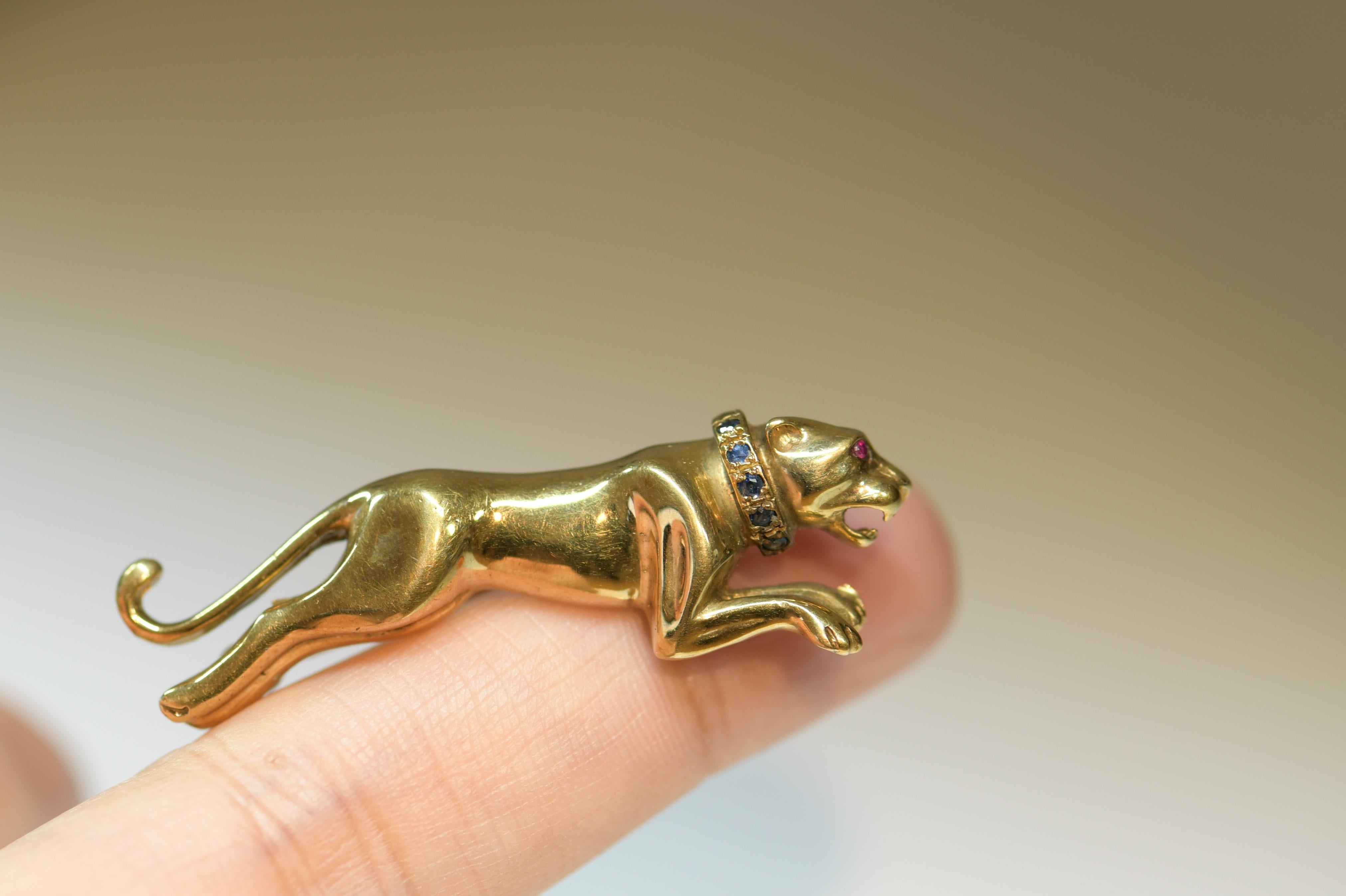 The brooch depicts a running panther and is set with two round-cut ruby eyes. This piece really shows excellent craftsmanship. This stylish vintage brooch would look fabulous on a vintage or modern outfit! Circa