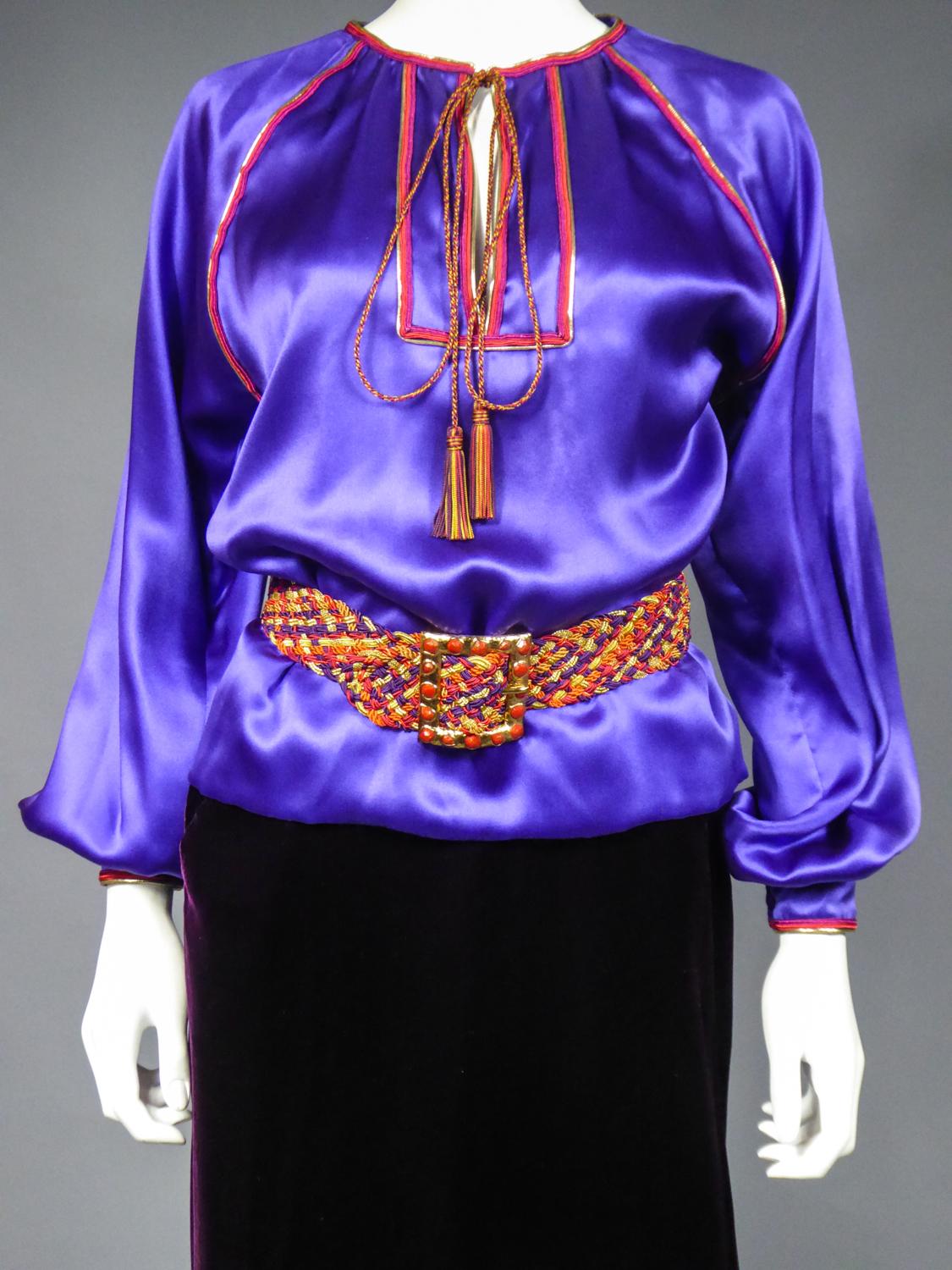 On hold for a french exhibition until November 2024, available after this date
Circa 2000

France

Iconic Russian blouse in purple satin and its skirt in cardinal silk velvet by Yves Saint Laurent Couture dating from the 2000s. Loose blouse with