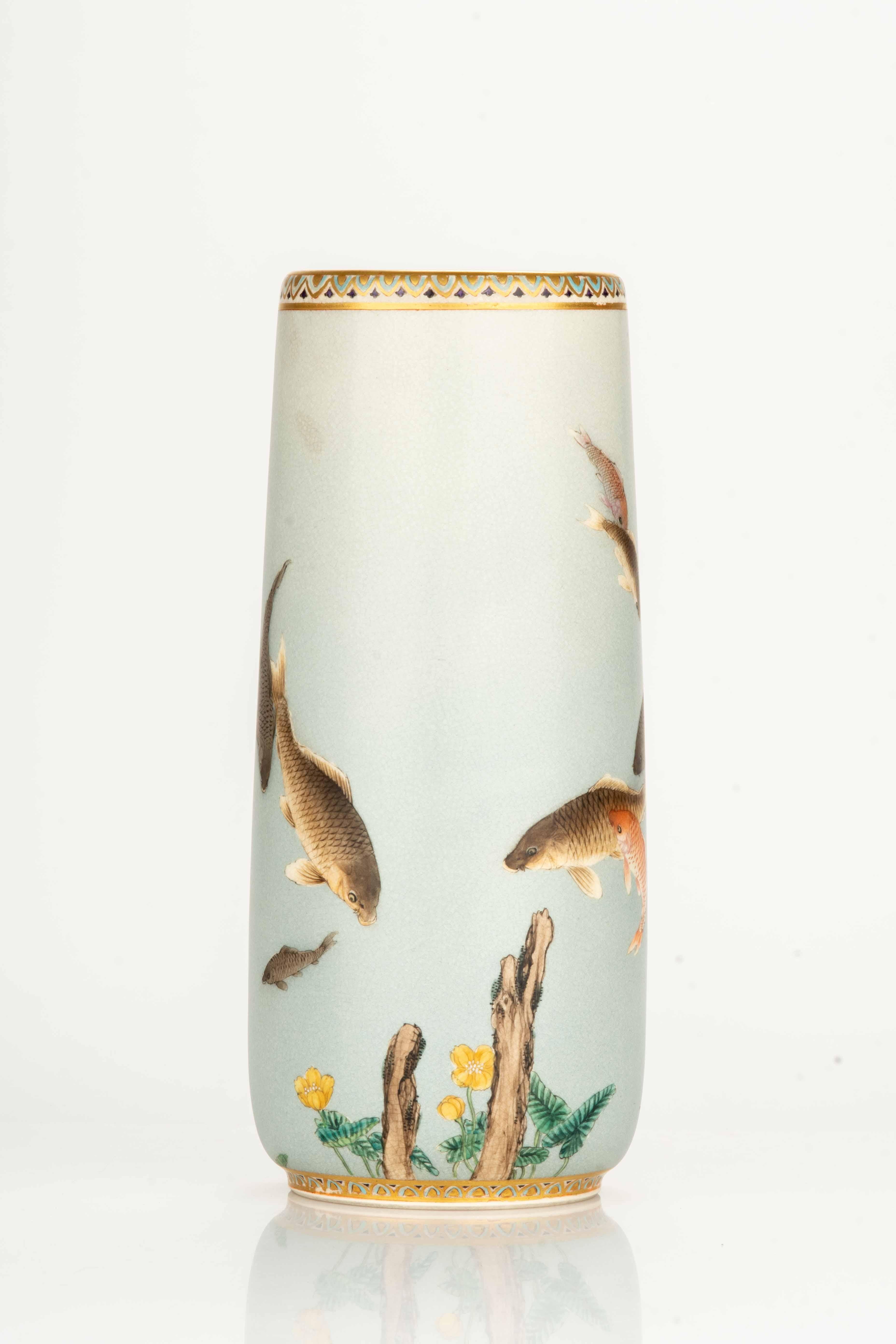 A Satsuma vase depicting a group of carp swimming in a stream. The scene is depicted from a shore perspective, where partially submerged tree trunks emerge and delicate flowers bloom along the banks.

The base and neck of the vase feature elegant