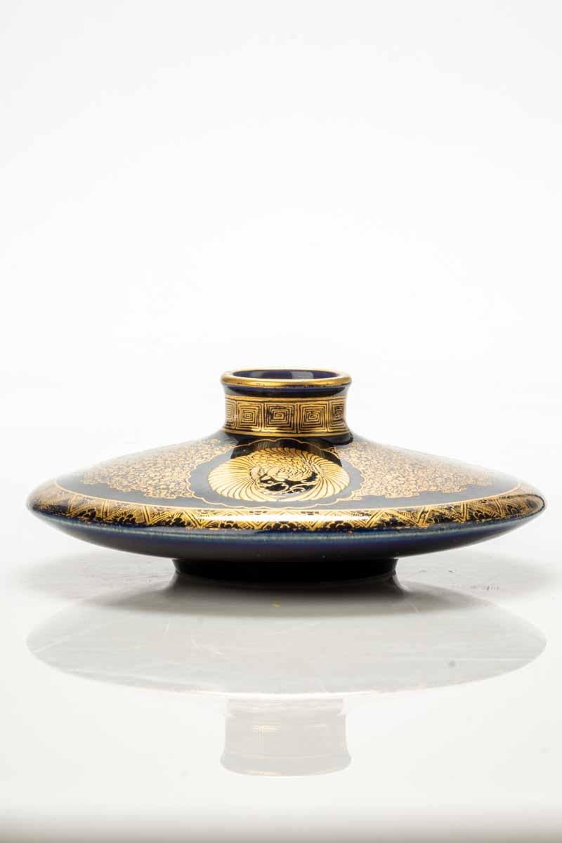 Vase en céramique de Satsuma en forme de disque, avec un fond bleu cobalt enrichi de fins détails dorés et de réserves qui abritent les trois mons.

Signée Kinkozan sous la base, à l'intérieur d'une réserve ovale.

Origine : Japon Japon

Période :