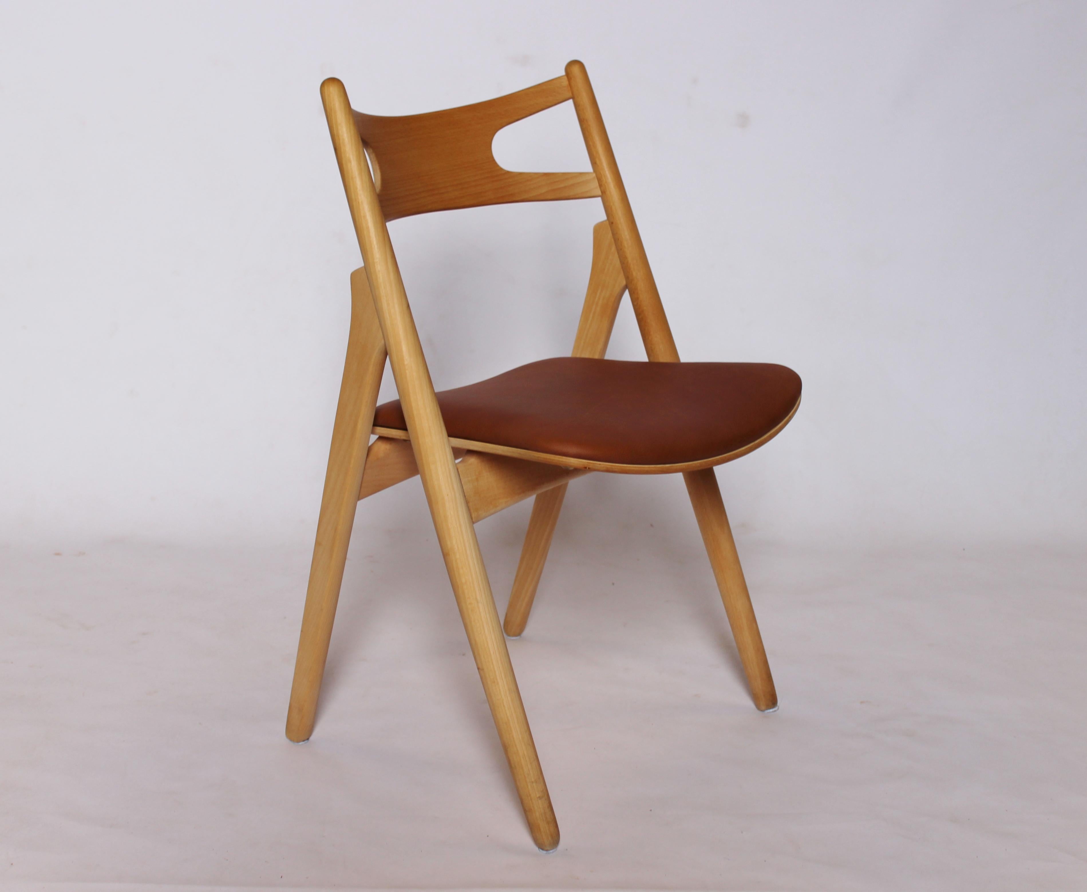 A Sawbuck chair, model CH29, designed by Hans J. Wegner in 1952 and manufactured by Carl Hansen & Son in the 1970s. The chair is made of soap treated beech and with seat of cognac elegance leather.