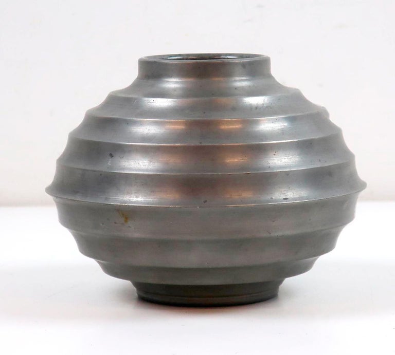 A Scandinavian Modern decorative pewter vase made in Sweden 1938, by unknown artist. Brushed matte surface. Stamped Svenskt Tenn, L8, Handarbete. Horizontal ribbons with relief effect. The surface may have scratches. Look att the pictures for