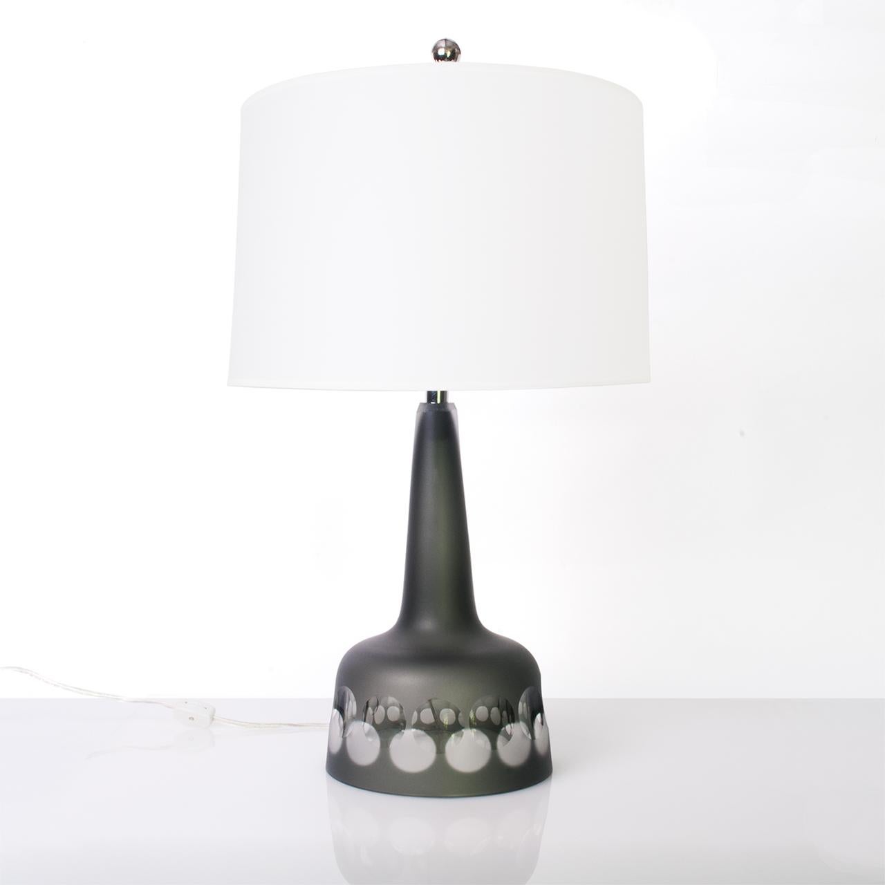 A Scandinavian Modern, Swedish Midcentury glass table lamp from Kosta studio in a grayish green and clear glass with circle pattern. Newly rewired and fitted with new nickel plated socket and hardware. Measures: Total height 23.5