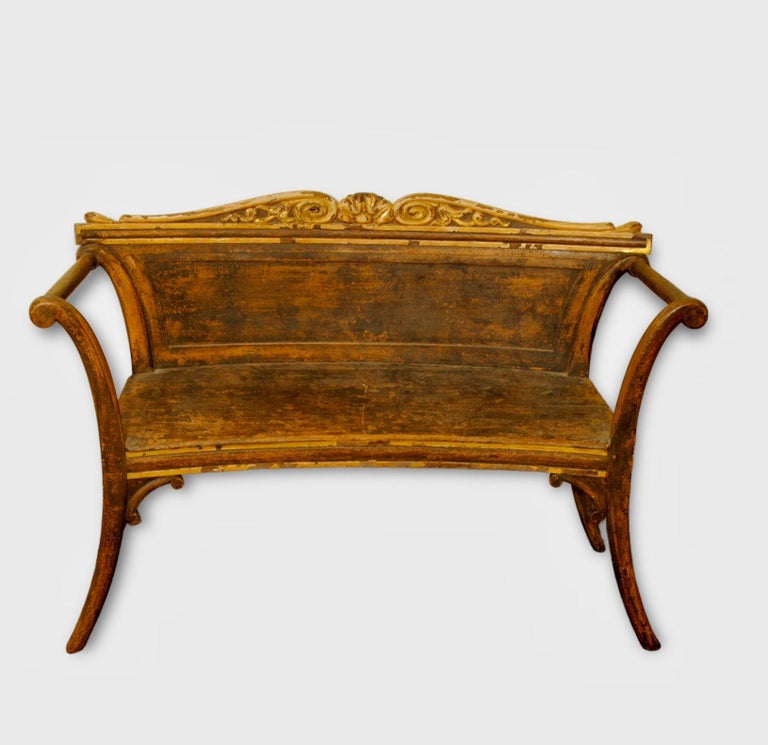A decorative painted and parcel gilt hall bench with carved top rail and out swept arms, Scandinavian late 19th century in regency style.