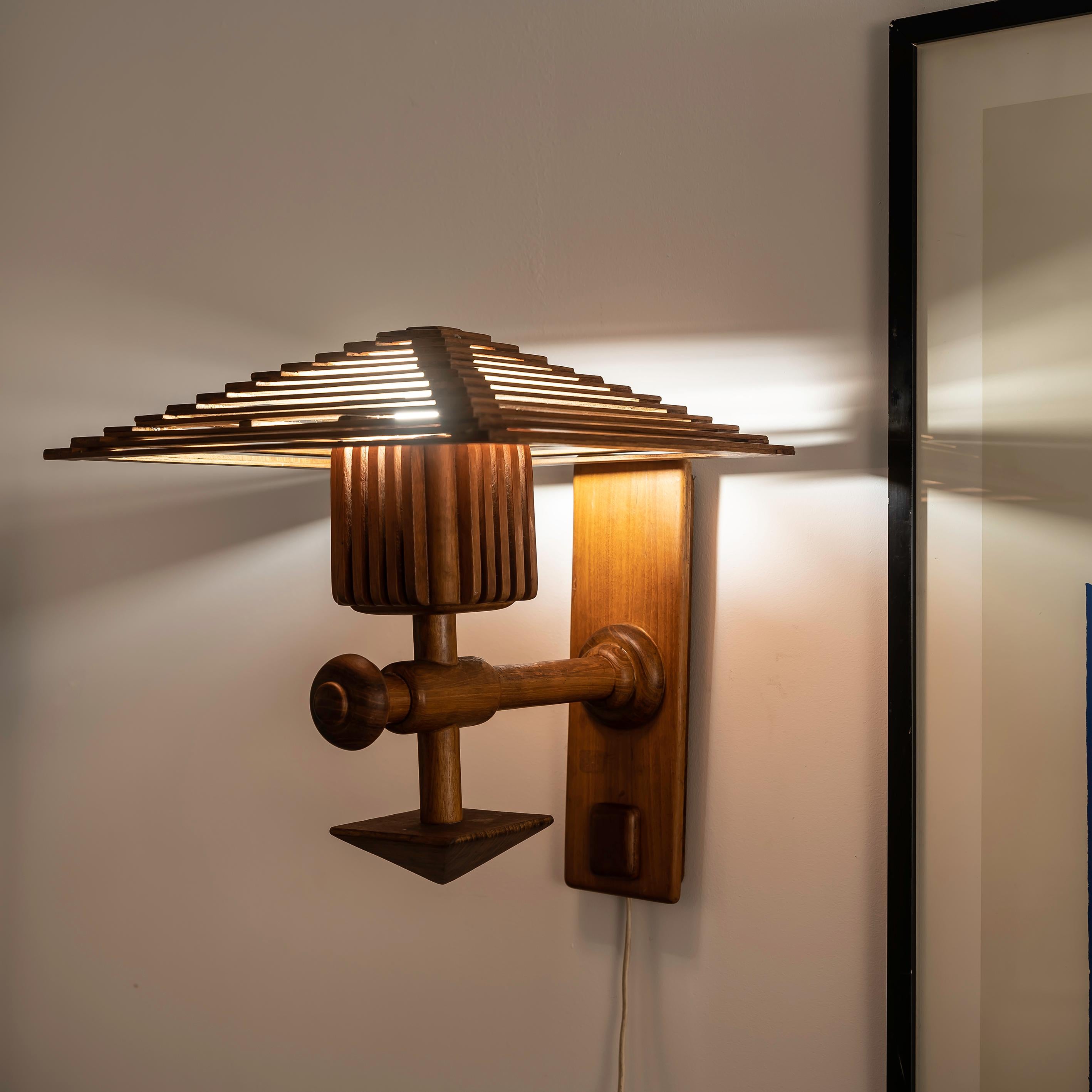Diese Wandleuchte aus Holz im orientalisch-skandinavischen Stil aus den 1960er Jahren ist eine einzigartige Verschmelzung zweier unterschiedlicher Designtraditionen. Das Ergebnis ist ein zeitloses und fesselndes Stück. Die Mischung aus