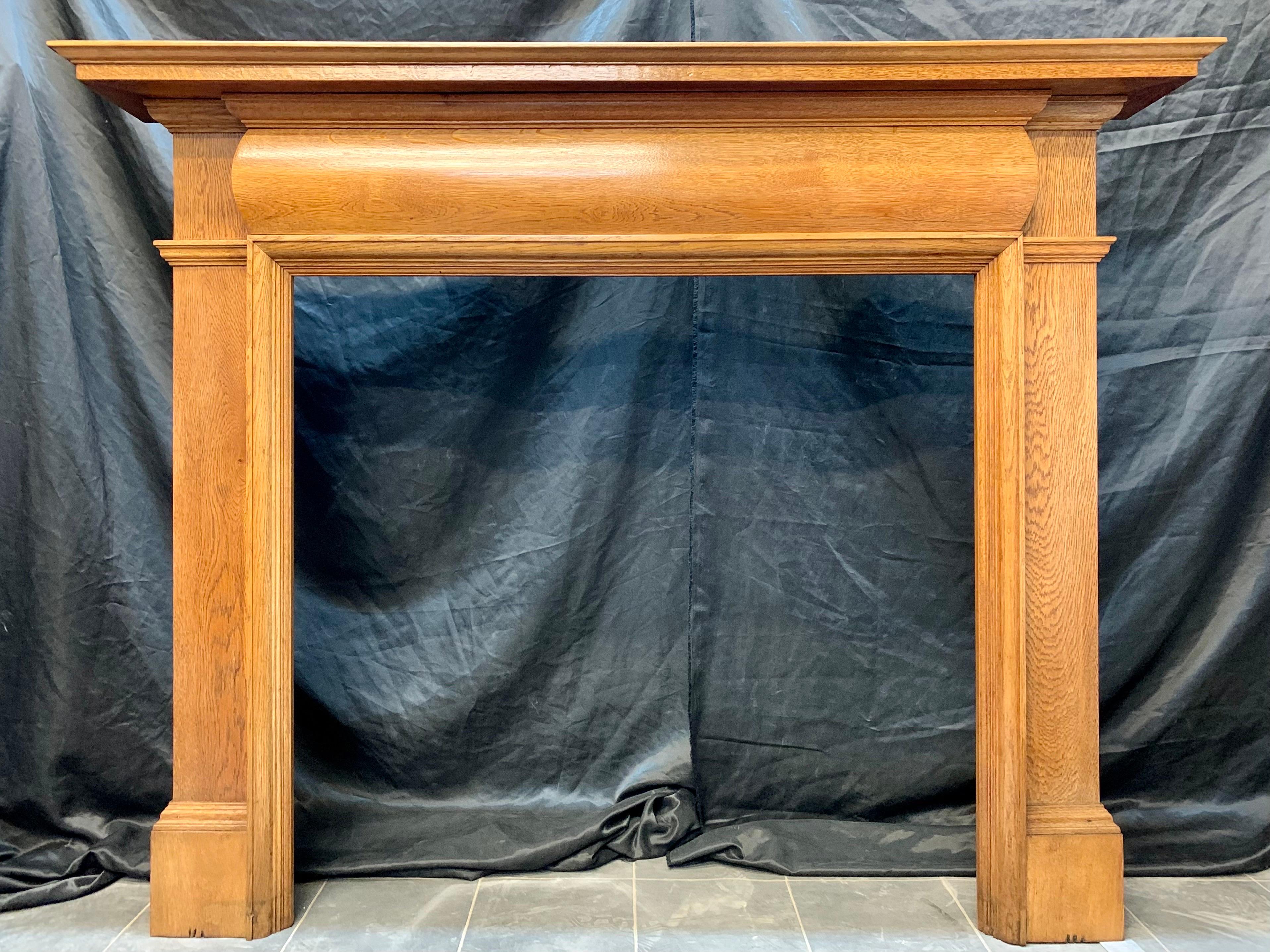 An Edwardian solid Scottish home grown well figured Oak fireplace surround salvaged from an important villa in Edinburgh, Scotland. 

A moulded top shelf with a secondary under shelf above a barrel moulded frieze, a framed raised moulding outlines