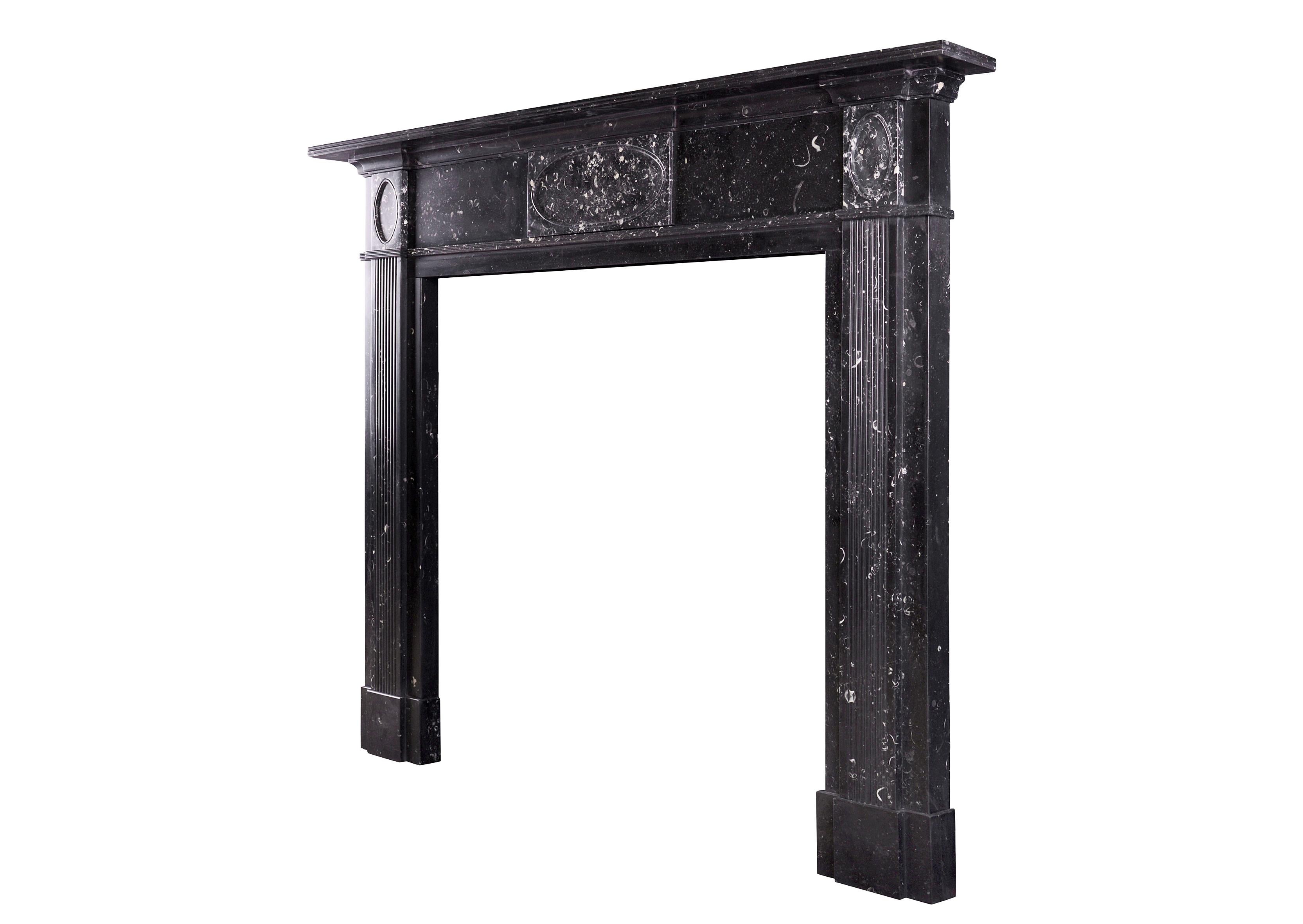 A Scottish Regency fireplace in black Kilkenny marble. The reeded jambs surmounted by plain frieze featuring oval centre and side blockings. Reeded detail to shelf. Early 19th century, circa 1810.

Shelf Width:	1704 mm      	67 ⅛