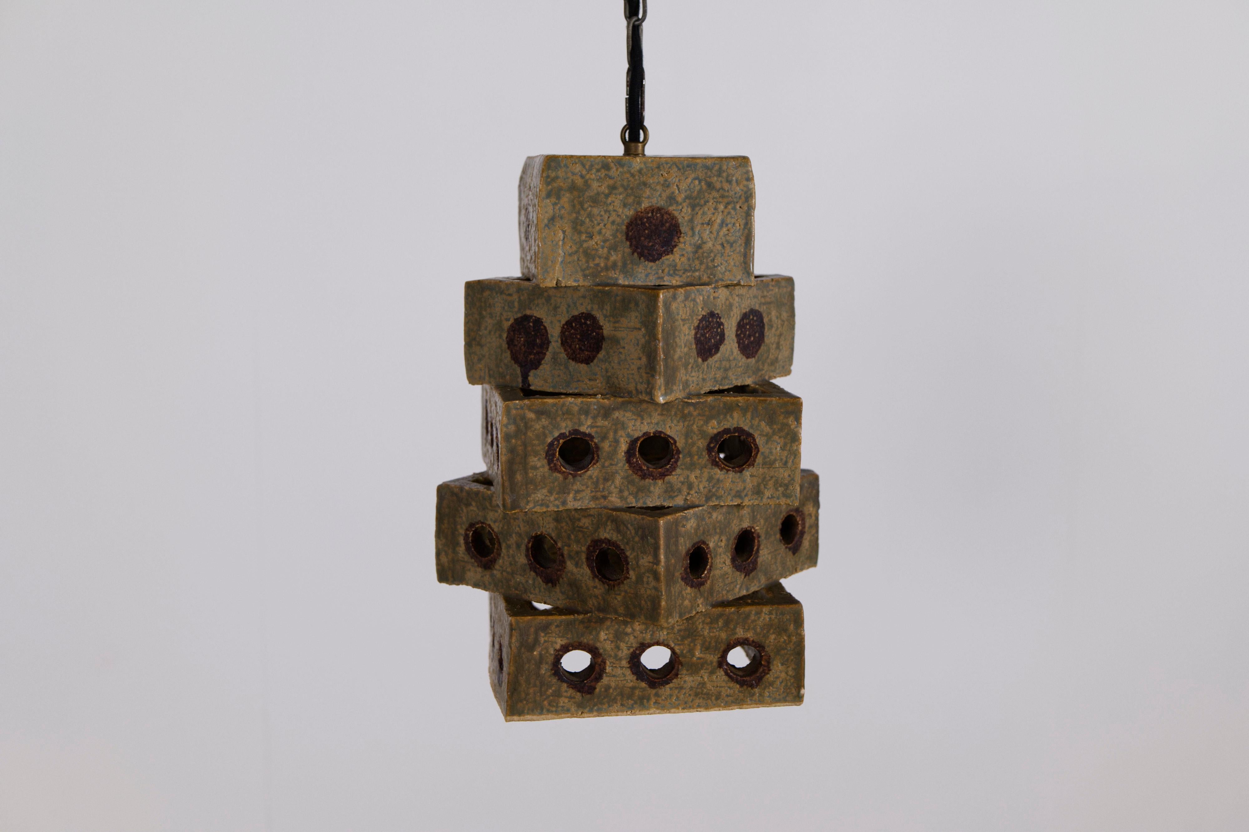 Lampe suspendue en céramique conçue par Aksel Christensen pour Marco Stentøj Keramik dans les années 1970. Un petit studio de céramique et un artiste du Danemark, possiblement une pièce unique. La lampe est composée de carrés de céramique empilés,