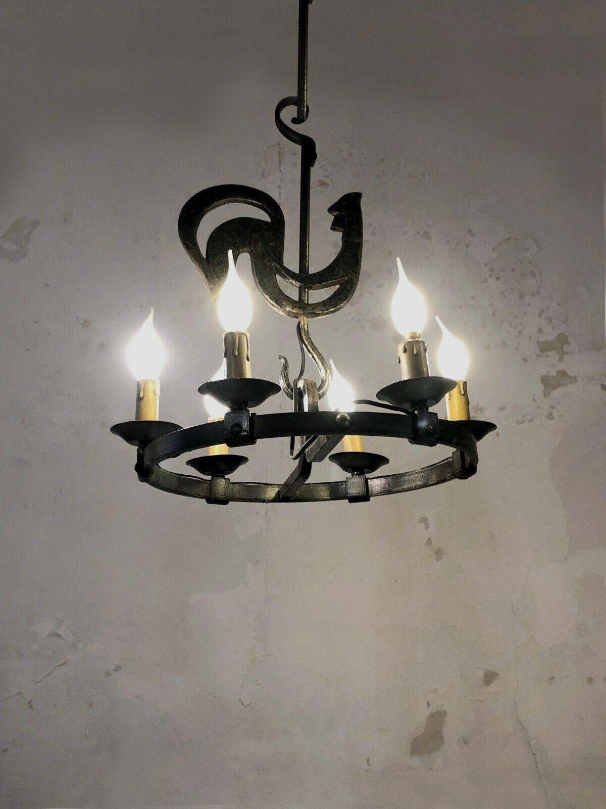 An impressive and sculptural circular rooster pendant light, Art-Popular, Brutalist, Rustic-Modern,  circular structure in solid hammered wrought iron, surrounded by 6 candle-style lights, in the spirit of the Artisans of Marolles, Jean Touret &