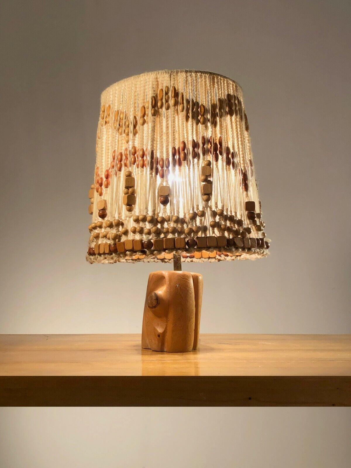 An exceptionally beautiful table lamp, Modernist, Hippie, Free-Form, Brutalist, Rustic-Modern, Folk Art, base in a superb piece of carved wood, topped with an incredible lampshade in rope and woven beads, to be attributed , France 1970.

DIMENSIONS:
