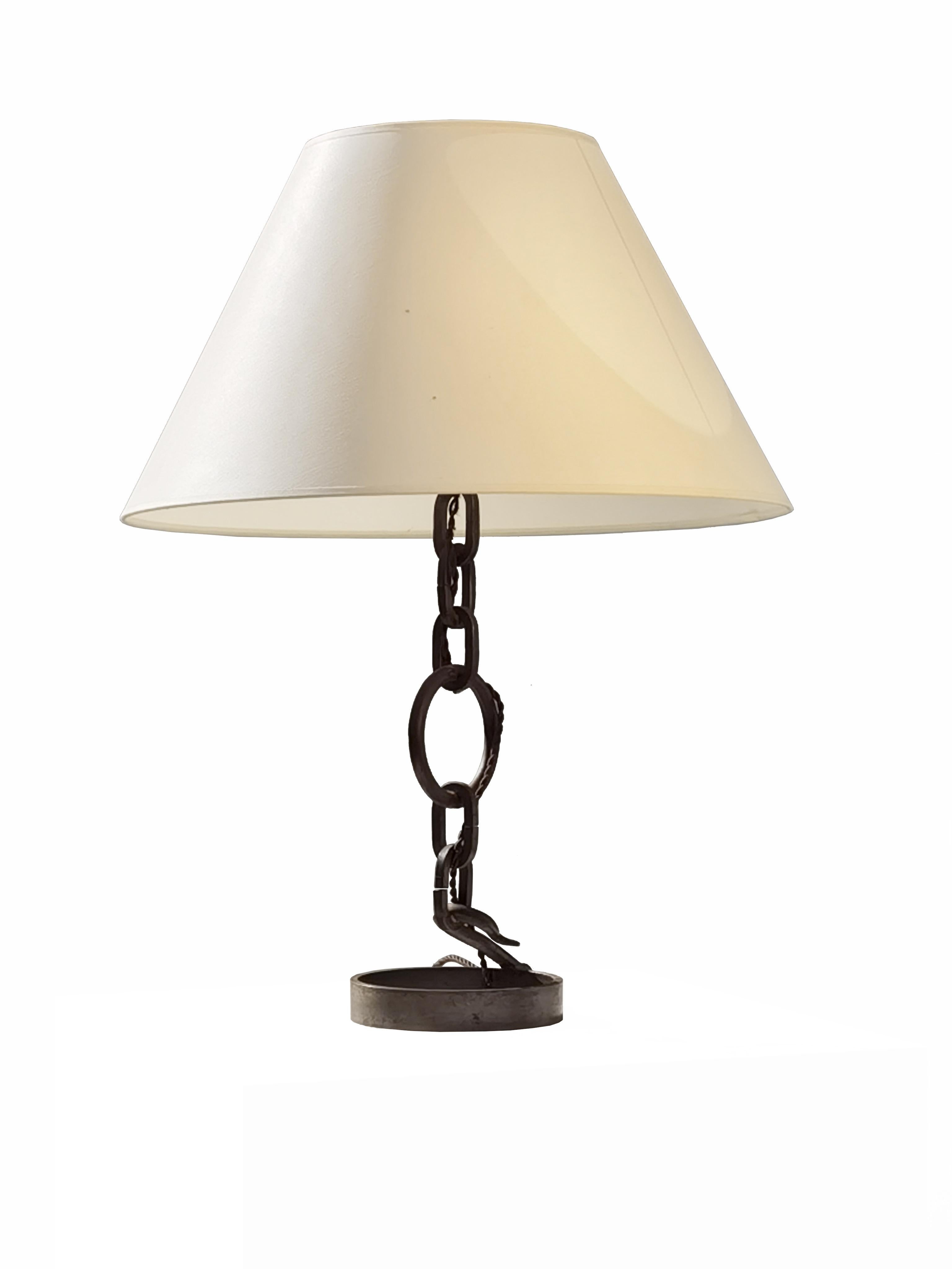 A singular and very beautiful wrought iron table lamp, made by a French ironworker from the 60s, by reusing mechanical and agricultural elements in wrought iron: it is a rigorous Rustic Modern, Brutalist, Modernist composition, combining a circular