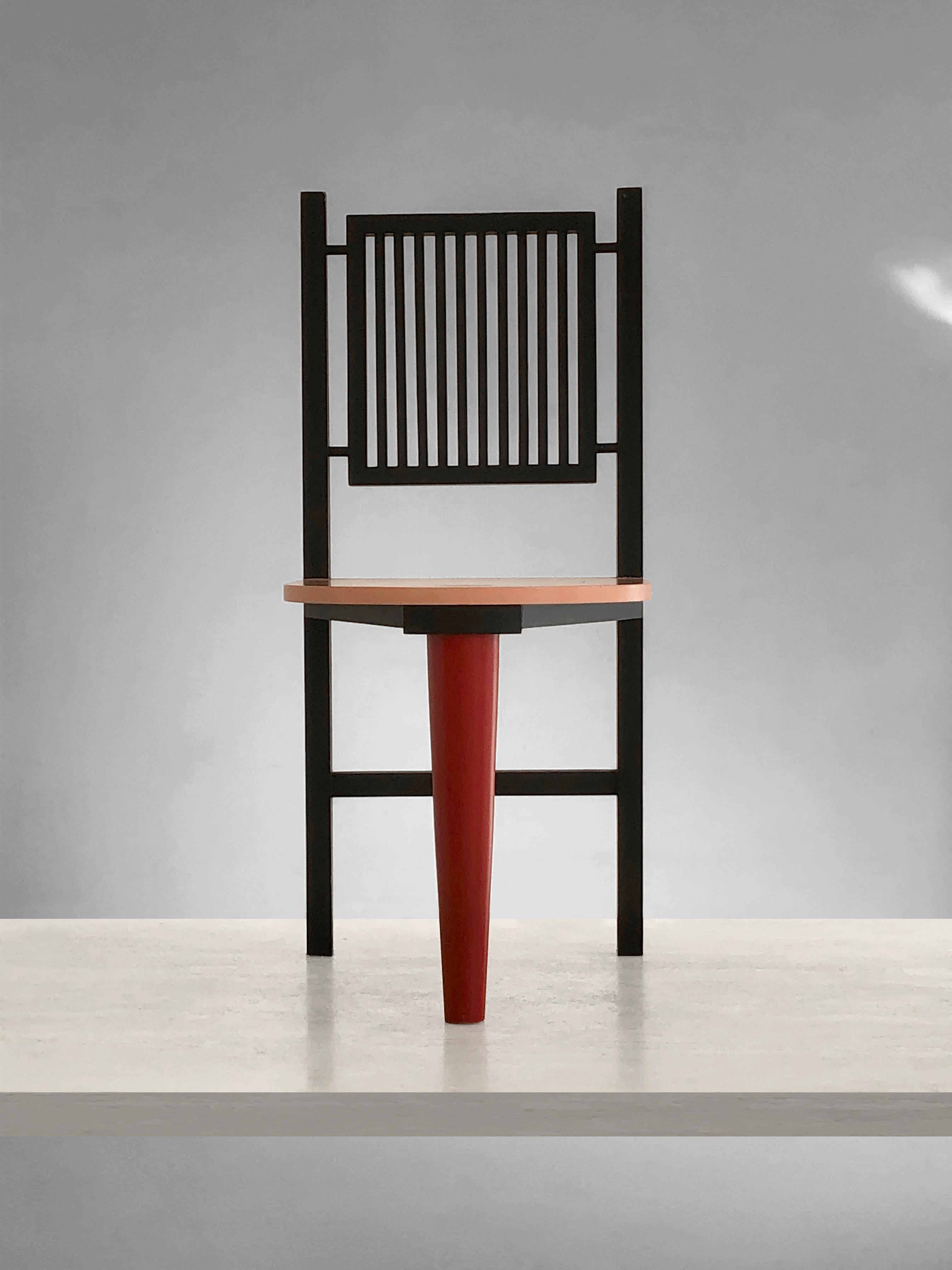 A sculptural postmodern chair, construction of geometrical pieces of wood based on 3 legs, straight grid black back, circular pink seat, red front leg, by anonymous artist, France 1980.

This piece remains radical postmodern designers as Andrea