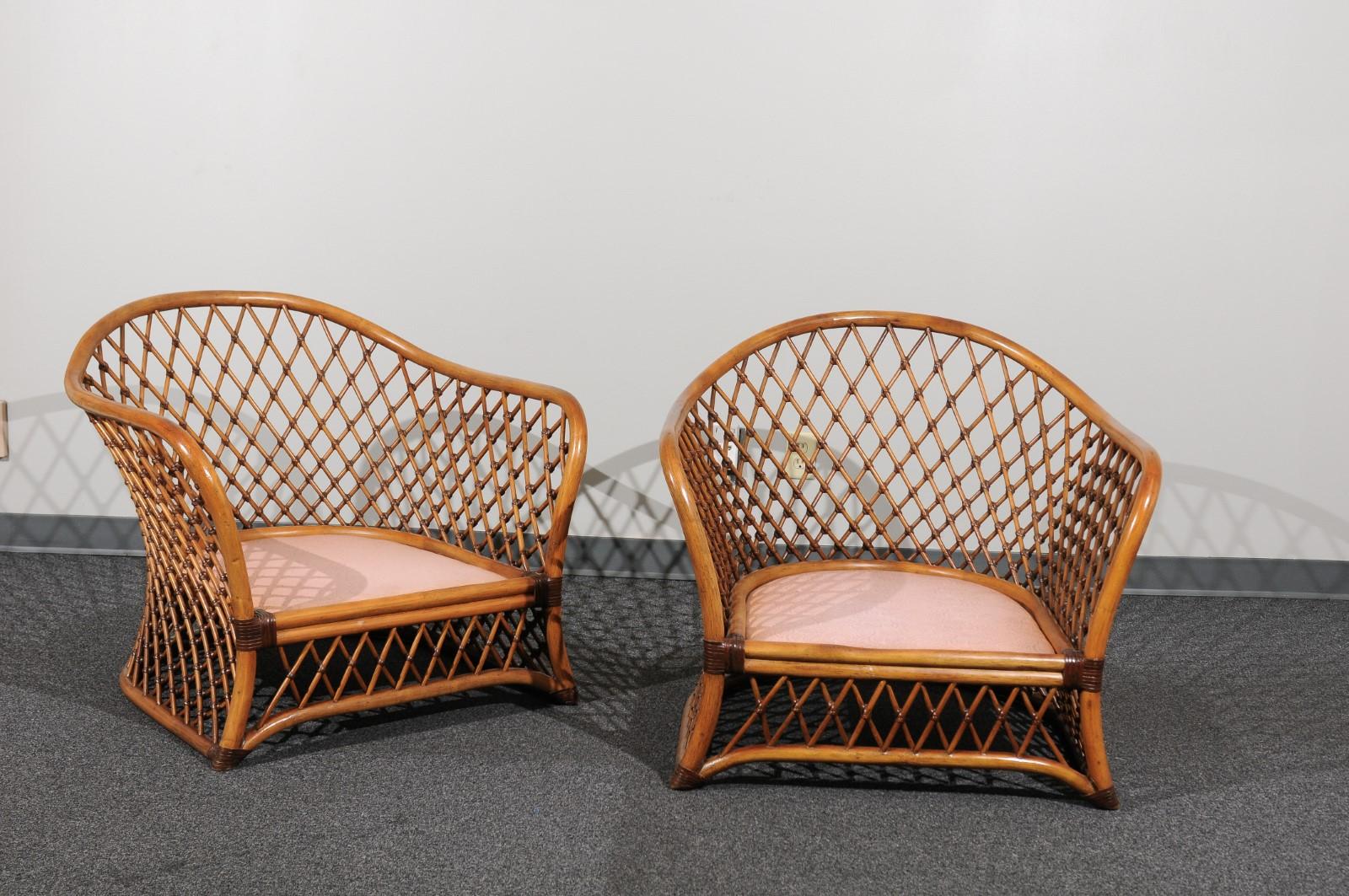 An exceptional restored pair of large scale vintage rattan club chairs. Stunning sculptural form with intricate lattice detail. Accents and bindings in Chocolate leather. Stellar design and craftsmanship. Fabulous room-defining pieces designed to