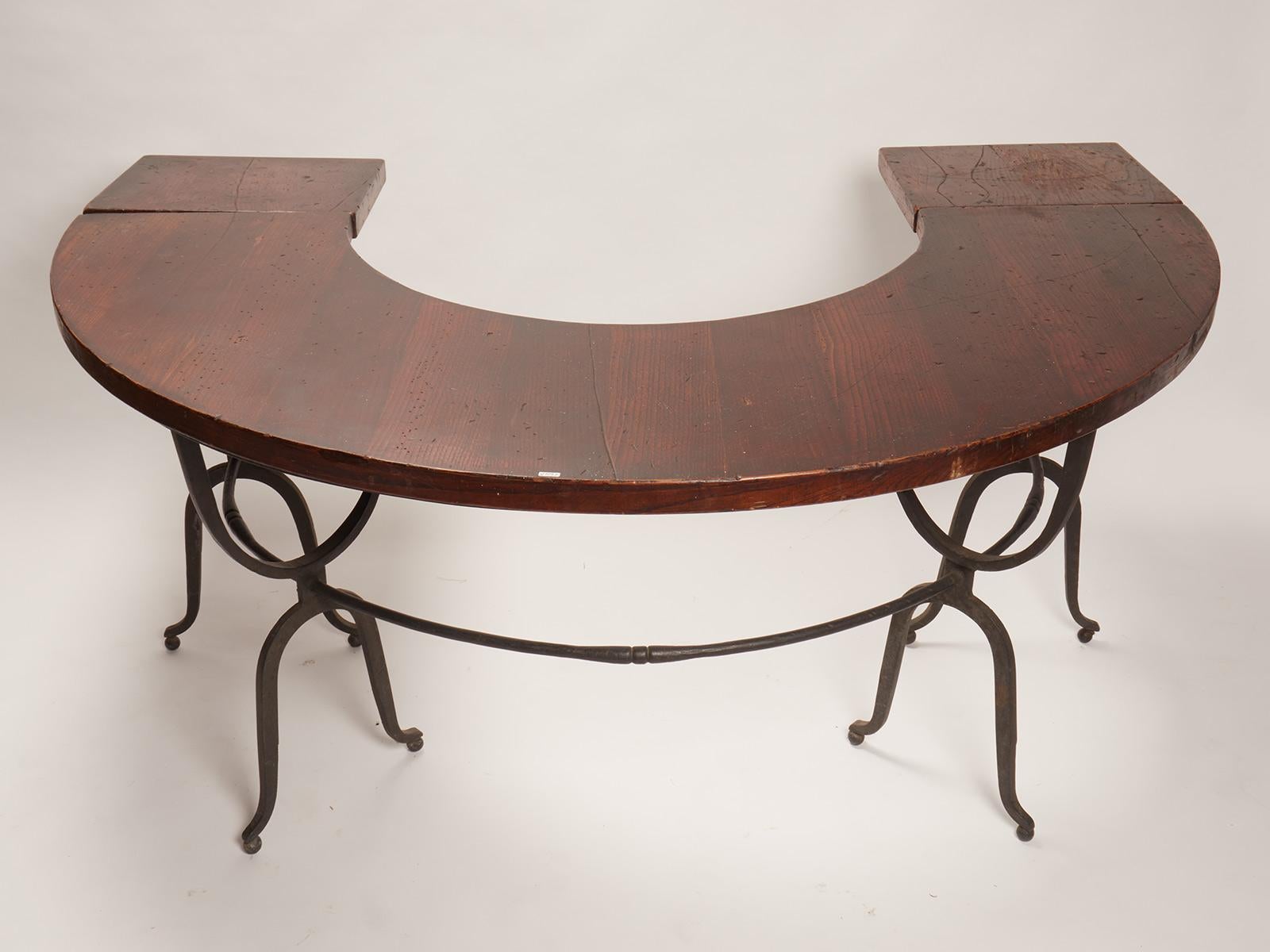 This unusual hunt table has cast iron arch shaped refined legs in an intrigued pattern and semi-circle shaped table, with a solid Teak wood shelf. Used for wine tasting. It has two extensions, one each side. United States, circa1900.