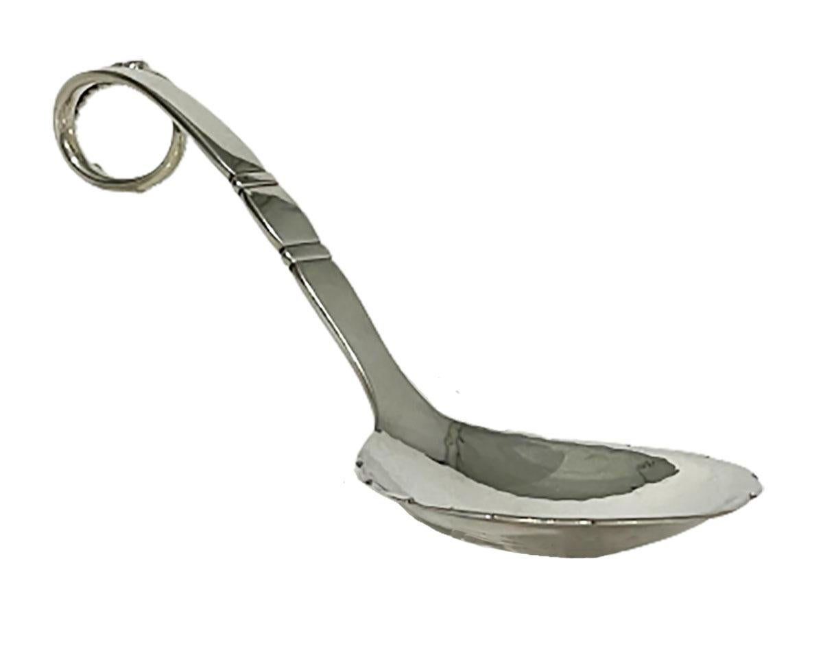 A serving spoon from Georg Jensen, model 41, Denmark (1945-)

A serving spoon from Georg Jensen with a curled handle with a round and sleek motif. The bowl of the spoon is slightly hammered and the edge serrated leaf motif. Model 41, Silver