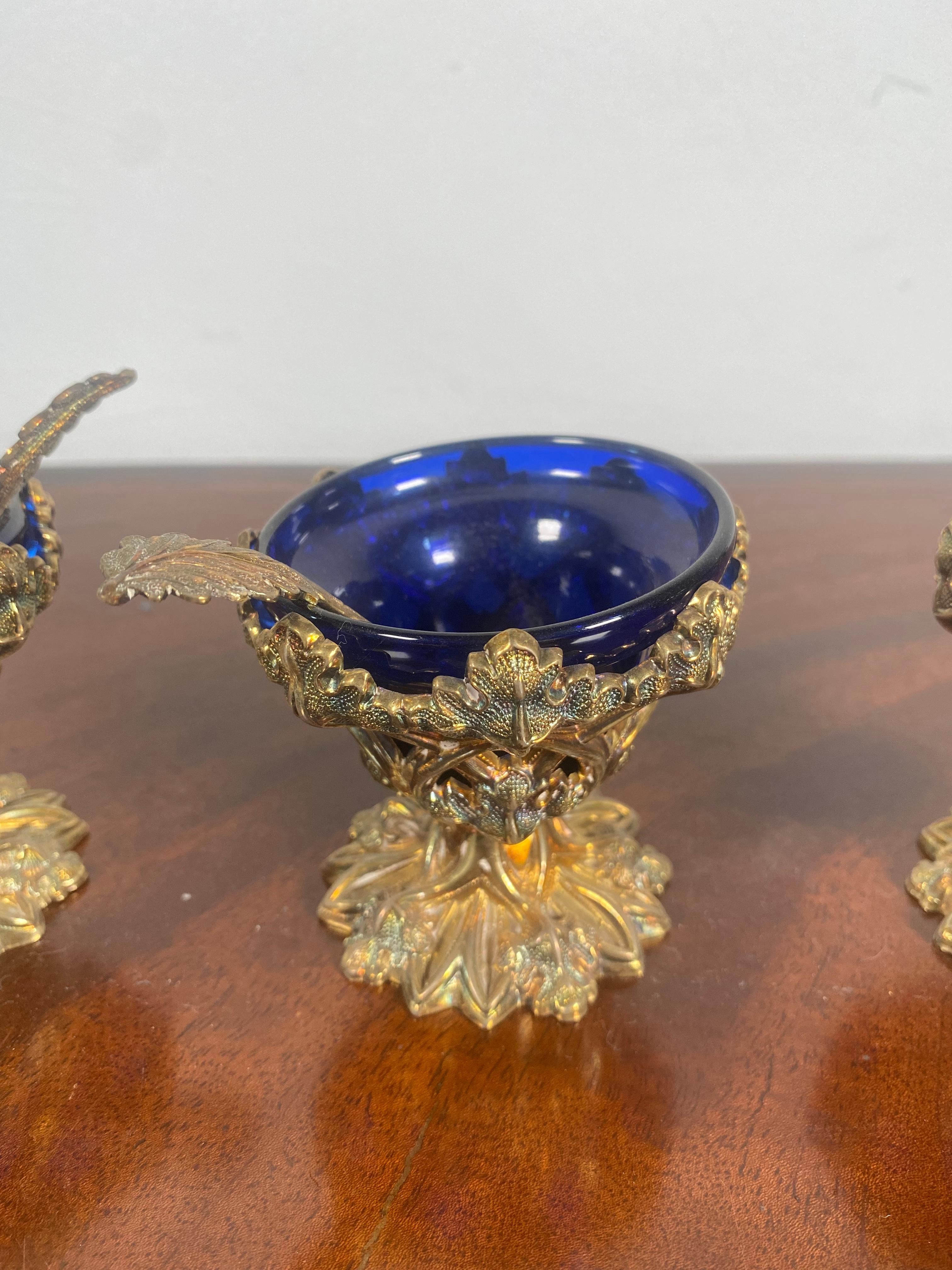 A beautiful set of 3 silver and glass mid-19th century salt cellars, each retaining its original spoon, each hallmarked.