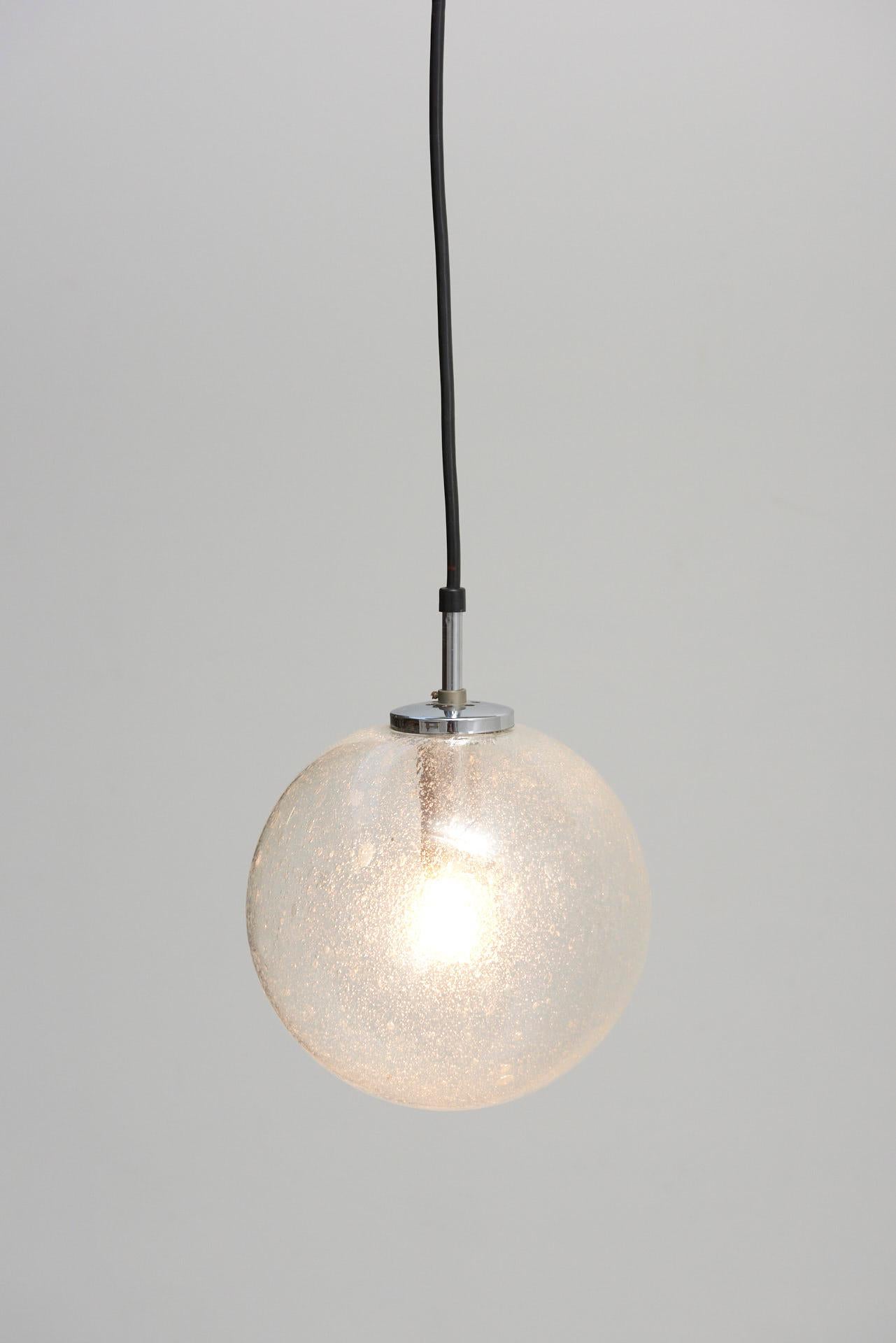 A set of 6 pendant lamps, with bubble glass spheres in various sizes. The spheres have chrome-plated suspensions. Made by Glashütte Limburg in Germany.