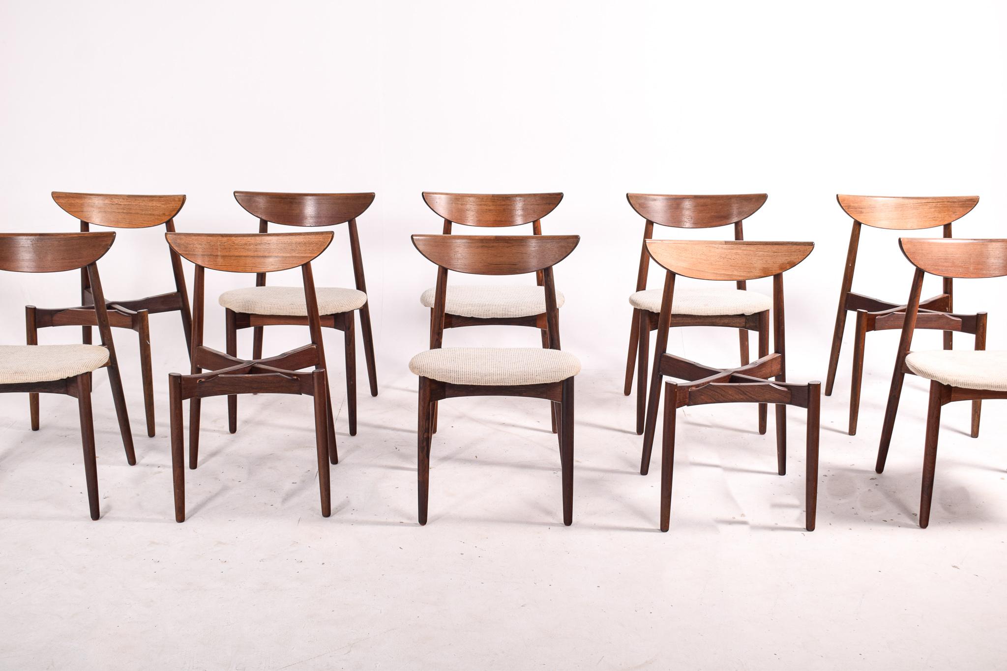 Stunning, solid rosewood set of ten dining chairs by one of the Danish great designers. Harry Ostergaard designed these dining chairs in the 1950s. The chairs feature elegant rosewood frames with curved backrests and tapered legs.