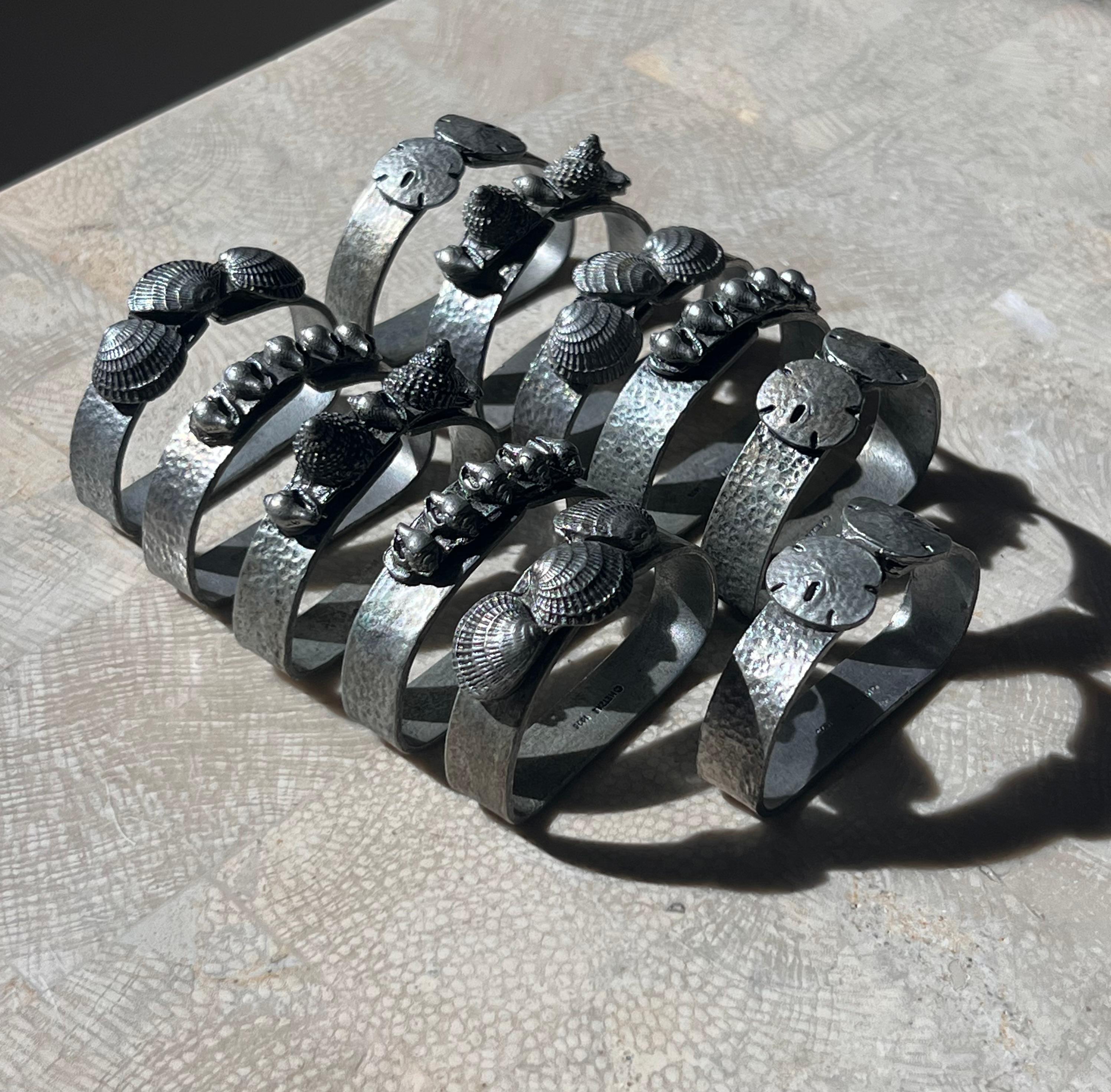 A set of 11 pewter napkin rings ft shells and sand-dollars, 1975. Pick up in central west Los Angeles or we ship worldwide.
Each ring measures approx 2.25” W x .45” D x 1.75” H 