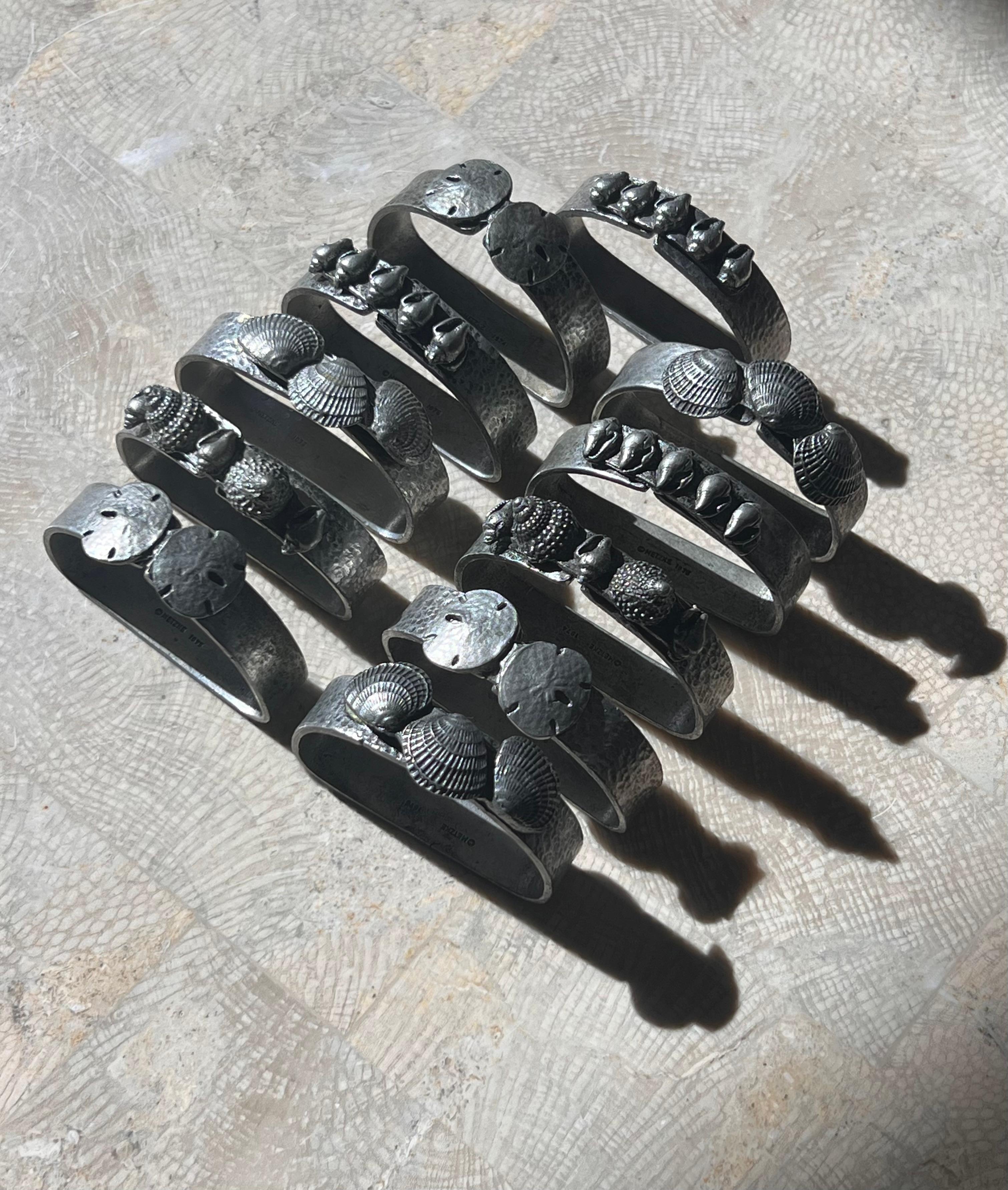 Brutalist A set of 11 pewter napkin rings with sculpted shells, 1975 For Sale