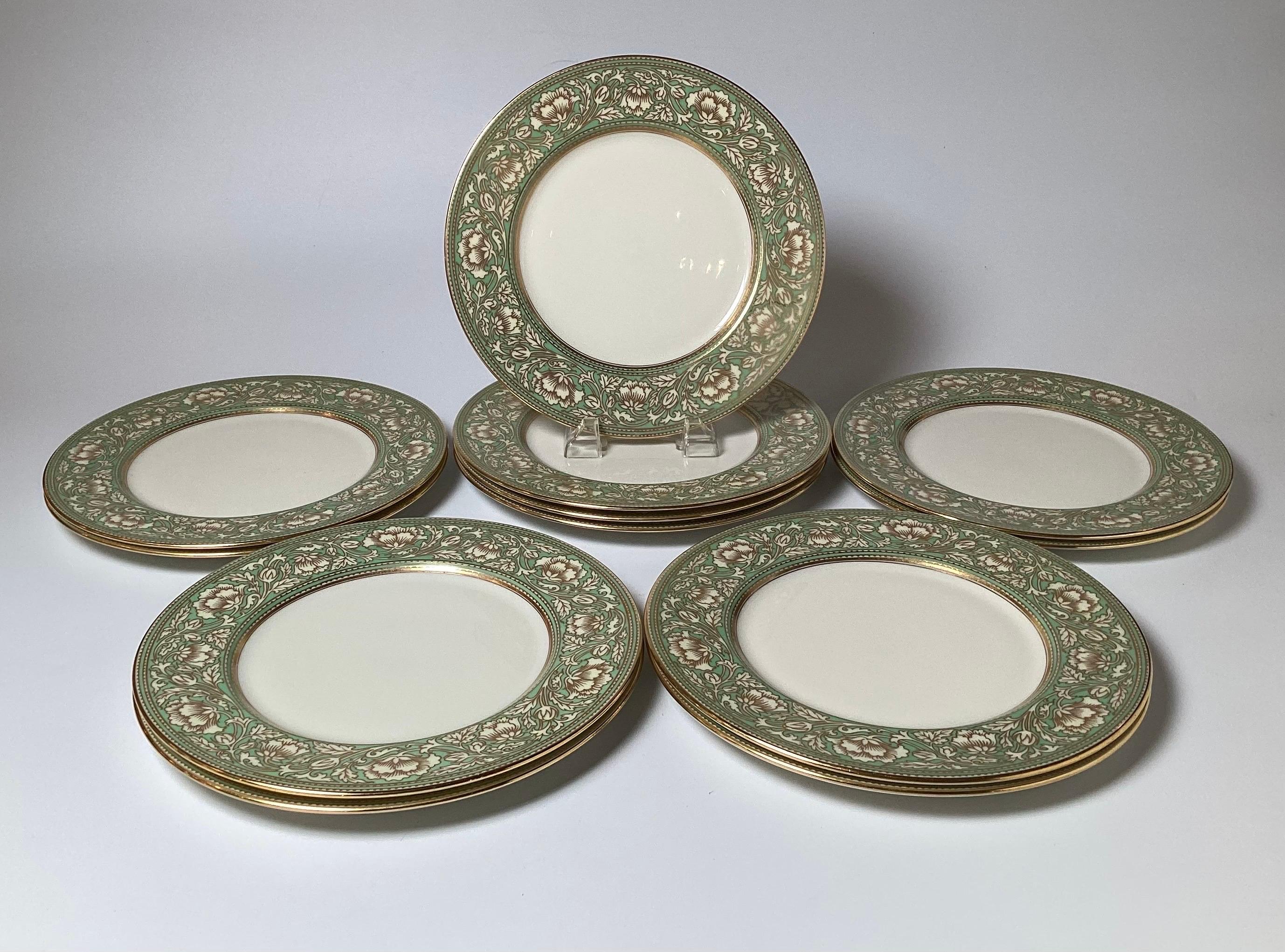 Élégant ensemble de 12 assiettes de service dorées et à bordure vert sauge. Les assiettes sont ornées de bordures florales en vert avec des détails de contour dorés. Les plaques ont été vendues par le premier bijoutier et détaillant de Philadelphie,