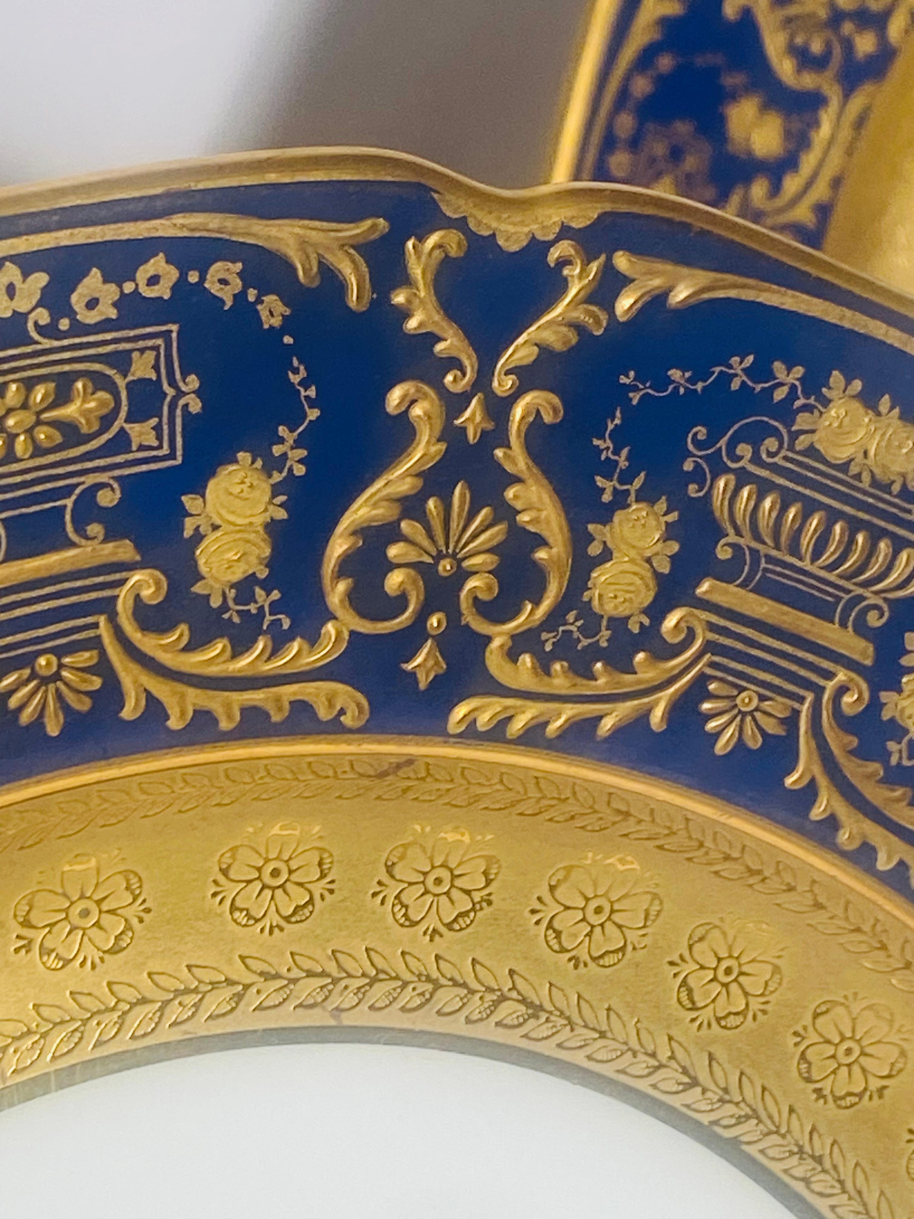 An attractive set of dinner or presentation plates by one of Limoges re known Gilded Age factories, William Guerin. This plate features an elaborate design of raised tooled gilding on their cobalt blue collars and an extra wide 24 karat gold acid