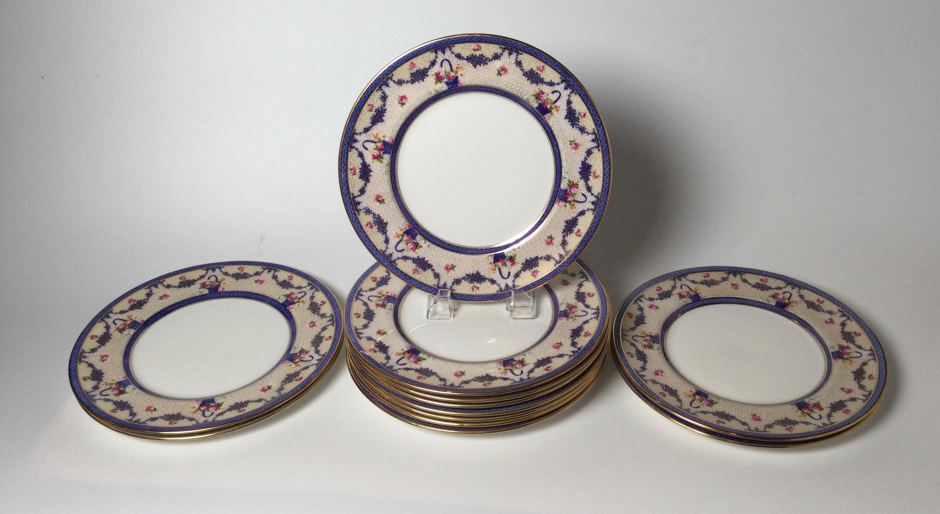 Elegant Edwardian service plates with gilt and floral borders by Herbert Betteley, the master decorator designer for Royal Doulton. The plates with cobalt and gold and floral decoration. England 1910.