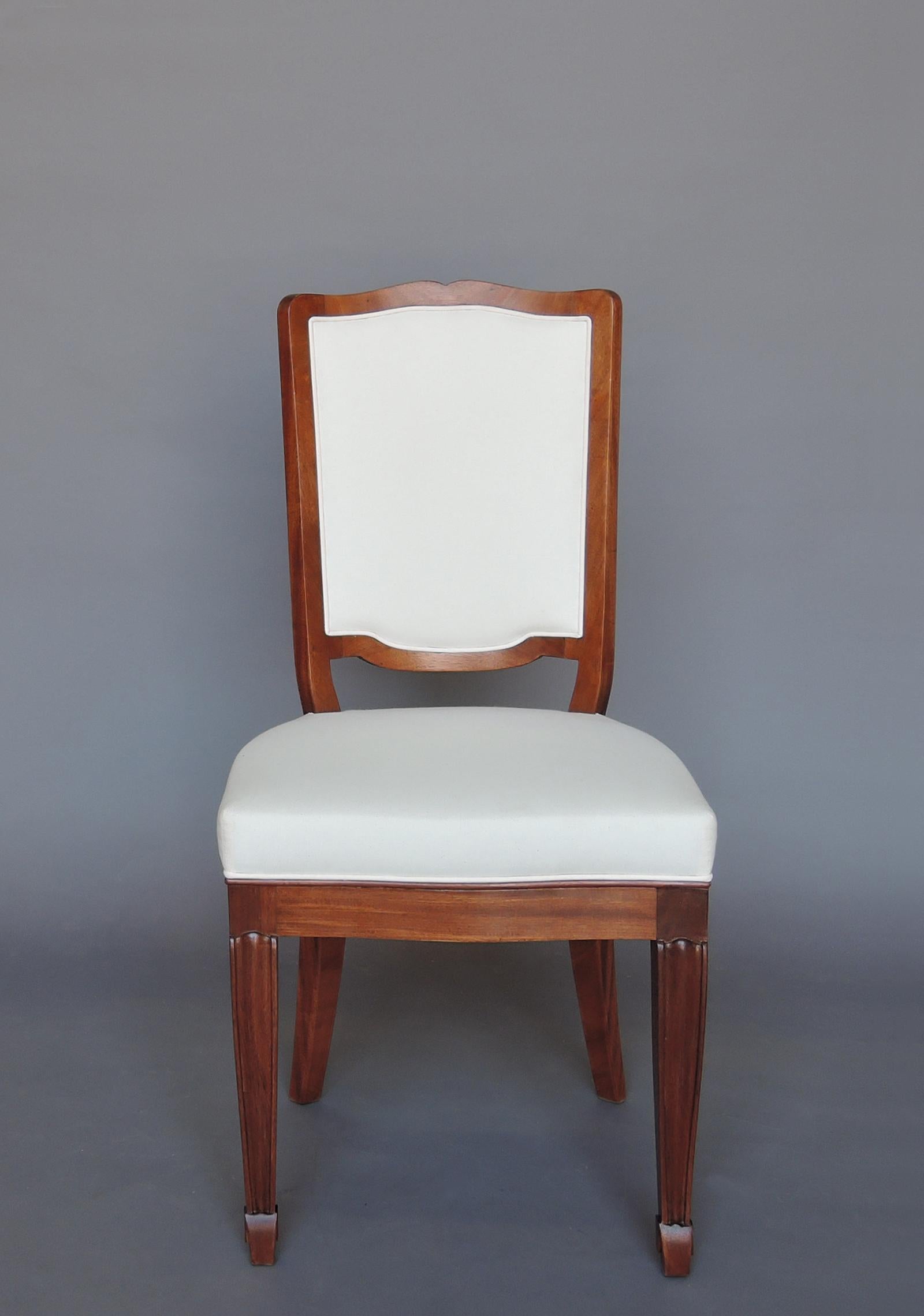Un set di 12 raffinate sedie da pranzo/sedie in mogano Art Deco francese, con dettagli intagliati, alla maniera di Andre Arbus. 
Sono disponibili anche un tavolo da pranzo e una console coordinati (vedi immagini). 
 